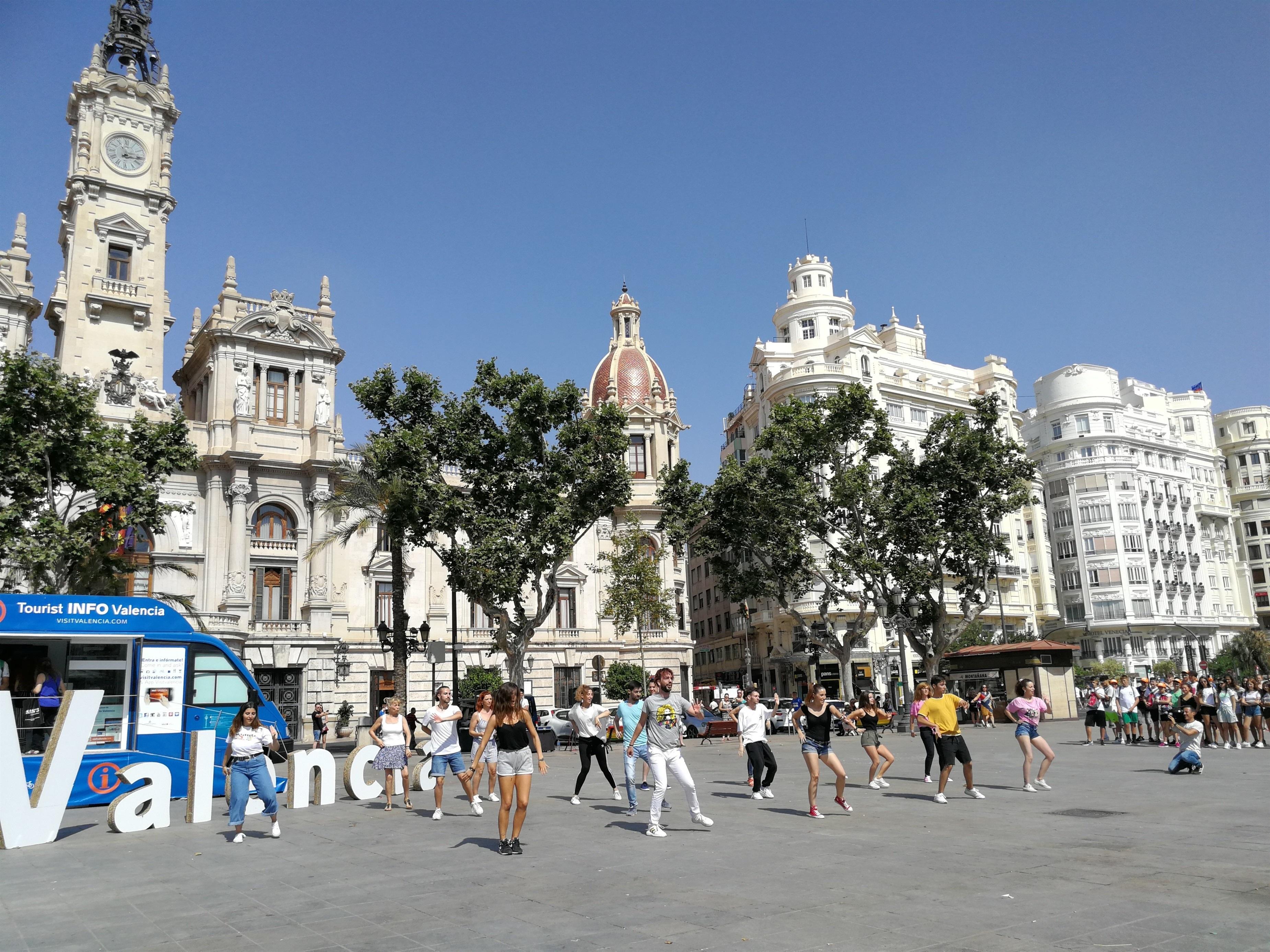 Un grupo de personas baila al lado del punto de información turística de Valencia - EP