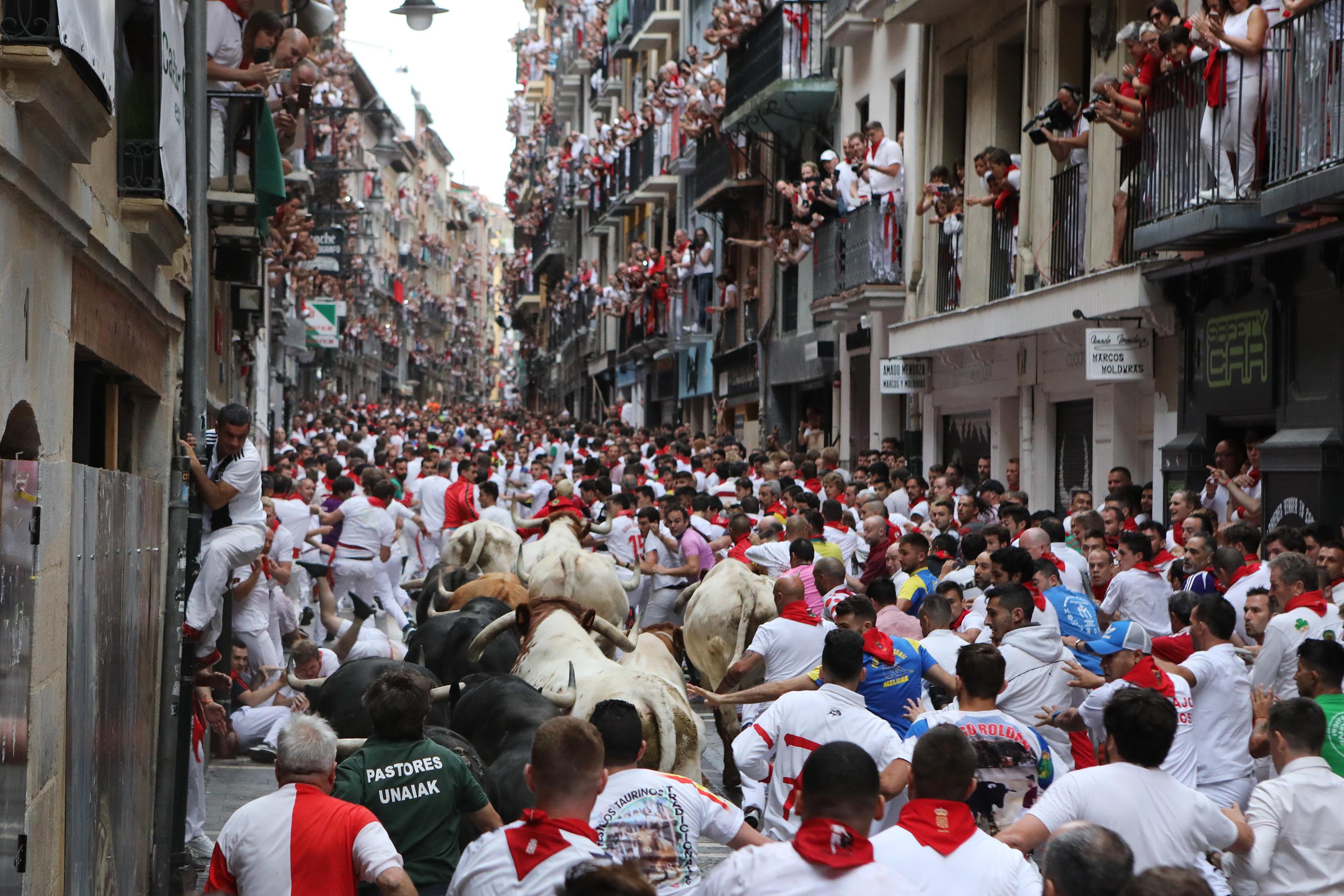  Decenas de personas corren delante de los toros en el primer encierro de las fiestas de San Fermín en Pamplona (Navarra) 