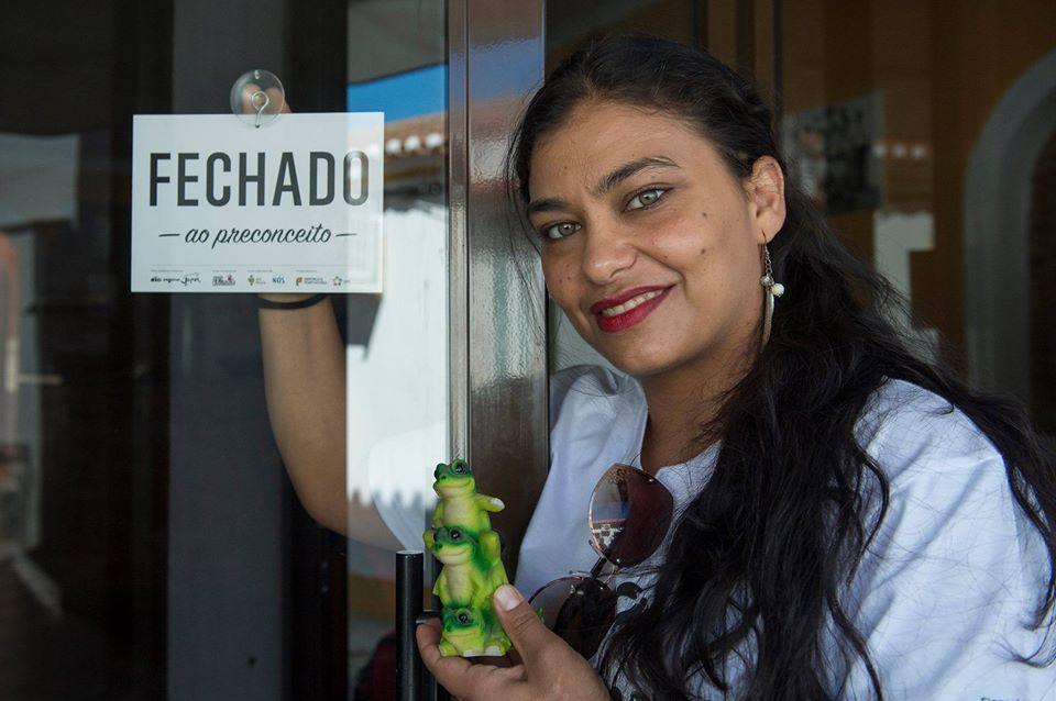 Una de las tiendas que colocó un sapo en su escaparate. En la foto una activista con un cartel que reza: 'Cerrado al prejuicio'