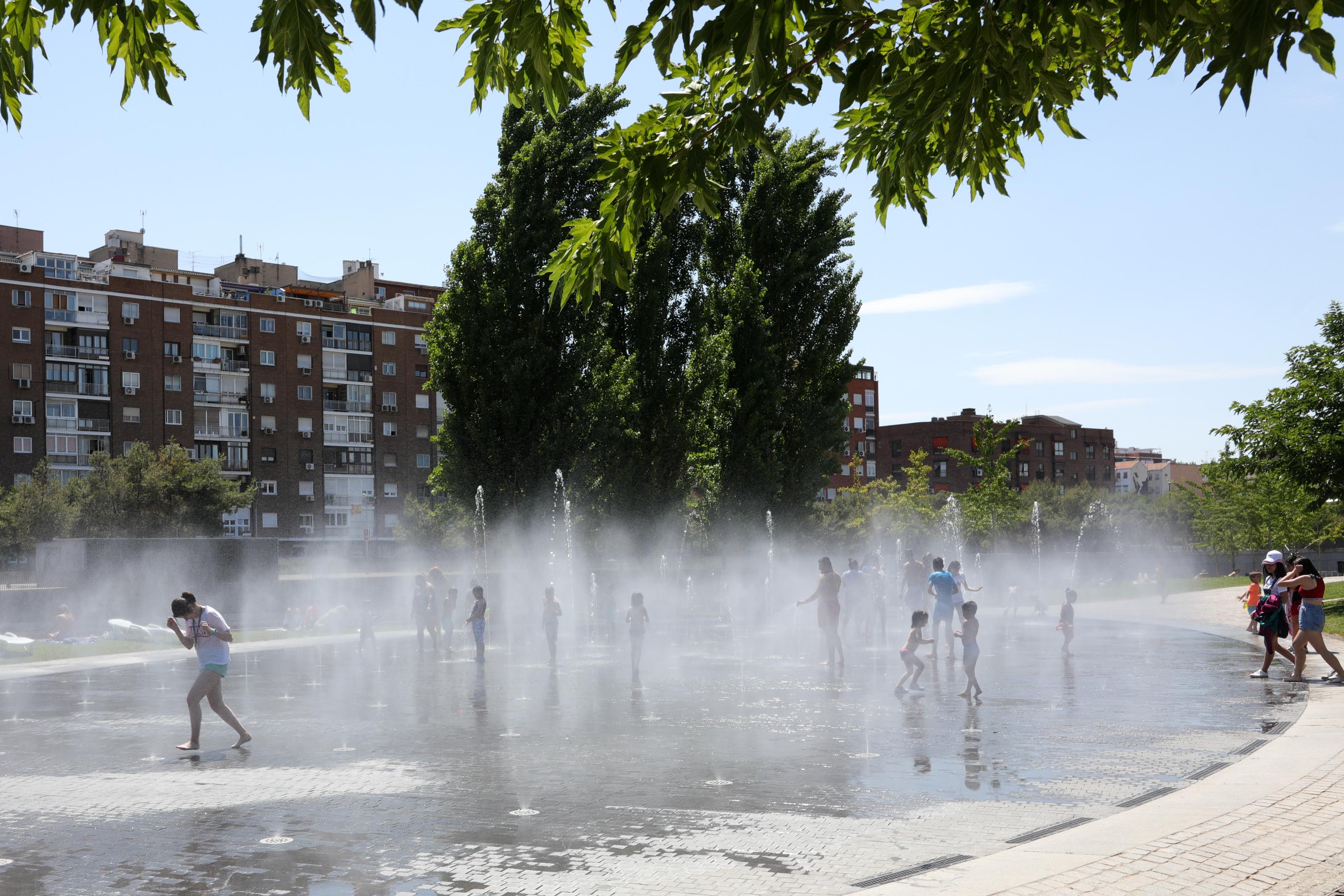 Varias personas se refrescan en los chorros de Madrid Río. EP