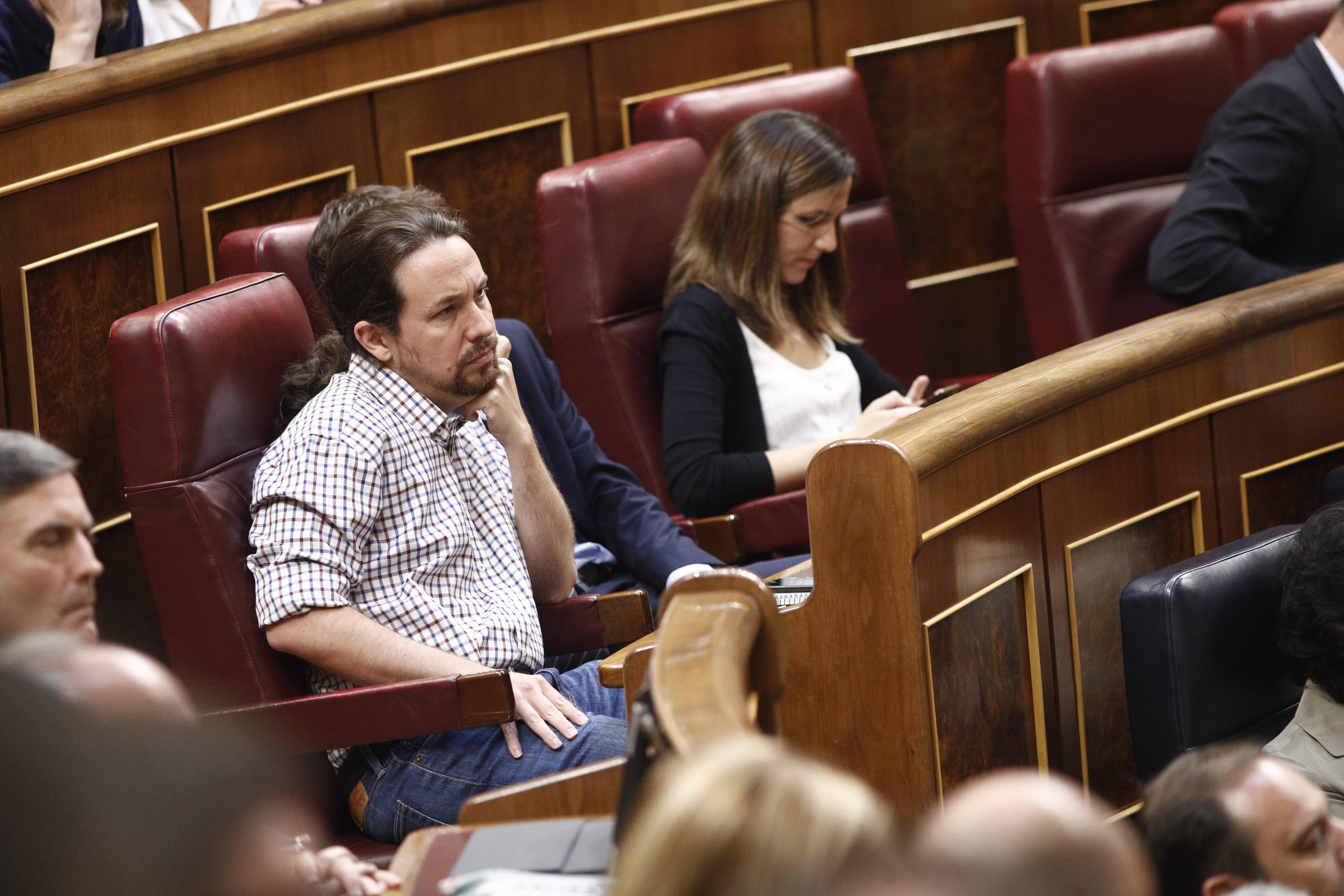 El secretario general de Podemos Pablo Iglesias escucha con gesto serio el discurso del presidente del Gobierno en funciones