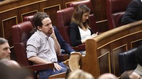 El secretario general de Podemos Pablo Iglesias escucha con gesto serio el discurso del presidente del Gobierno en funciones