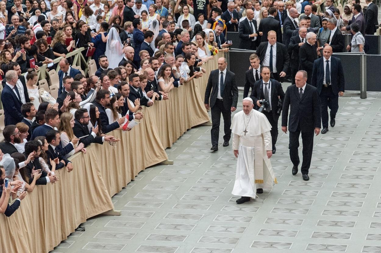 El Papa Francisco camina frente a algunos fieles