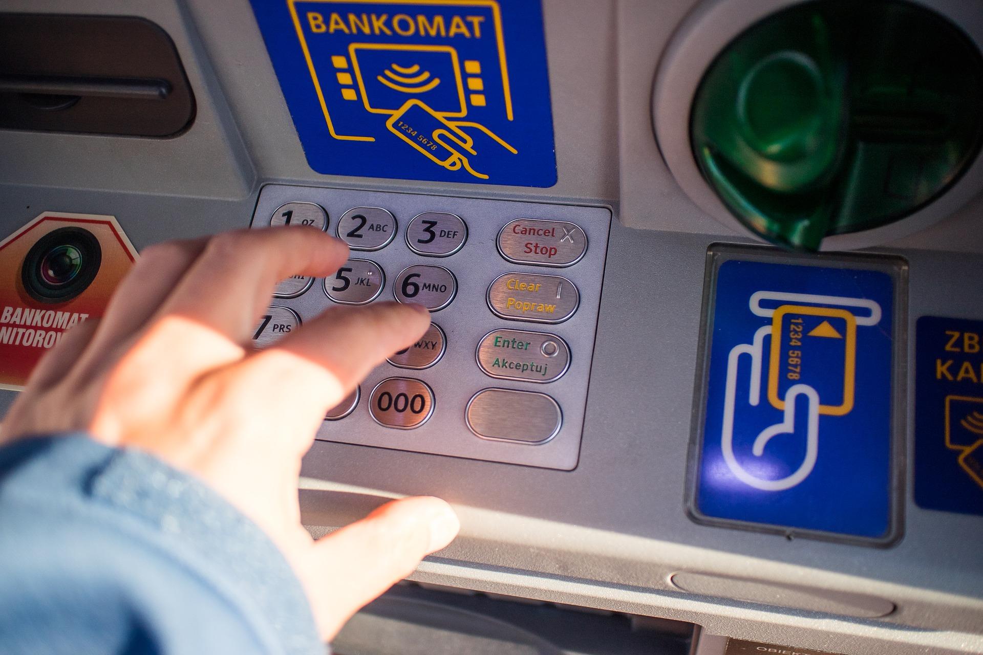 Una persona saca dinero de un cajero automático. Fuente: Pixabay.