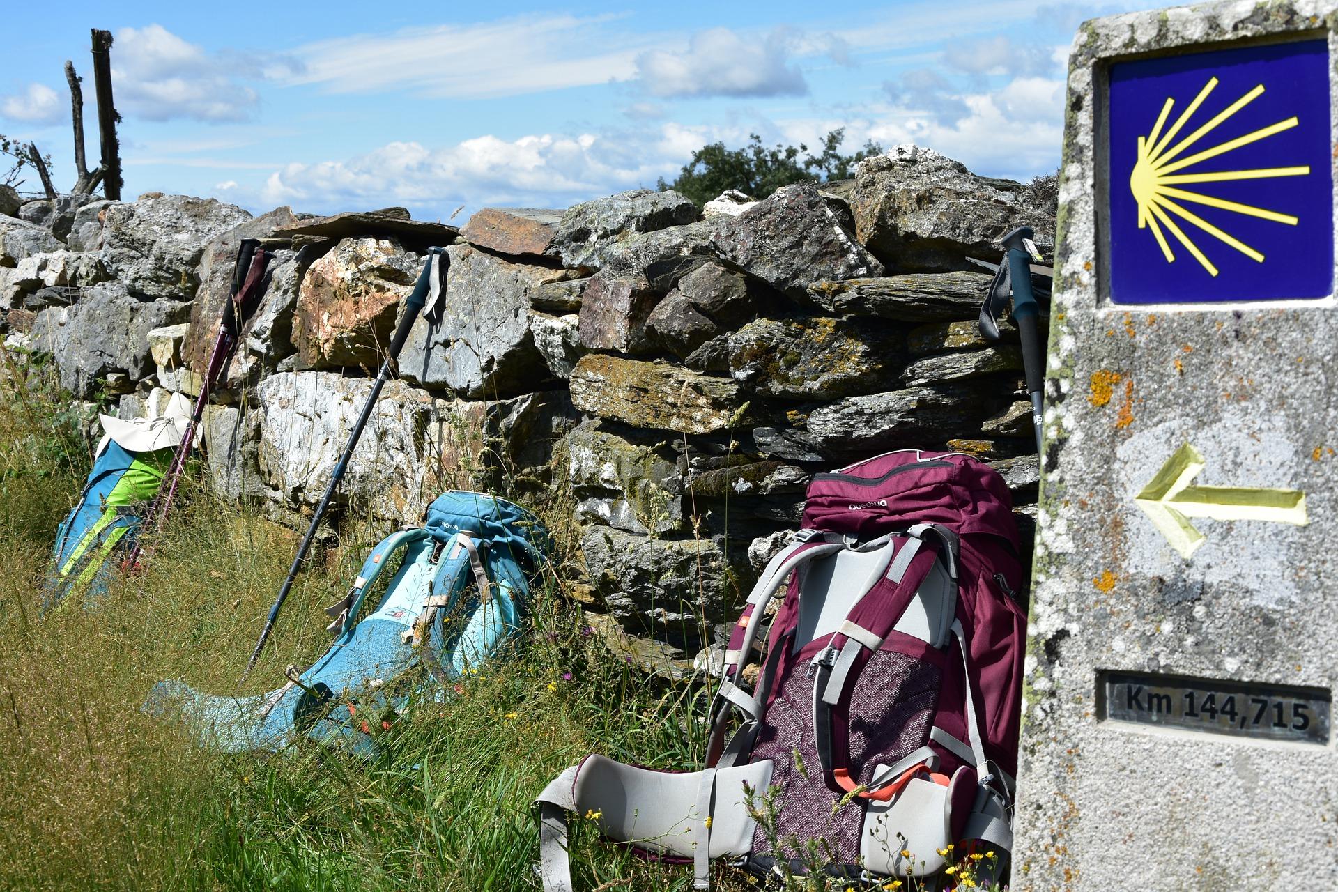 Varias mochilas descansan al margen del Camino de Santiago. Pixabay