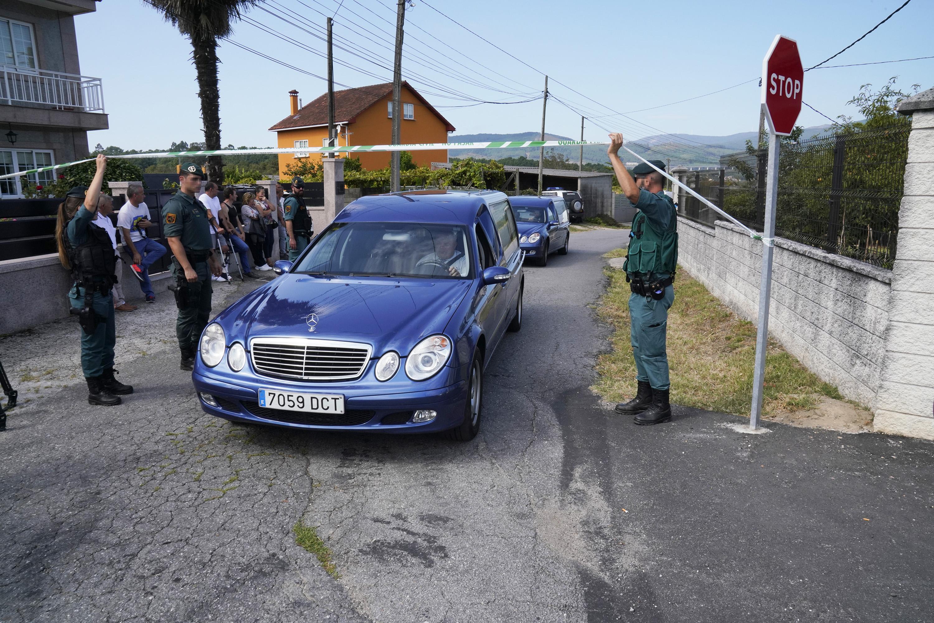 Salida de un coche fúnebre con el cuerpo de una de las víctimas del tiple crimen en el concello de Valga. EP