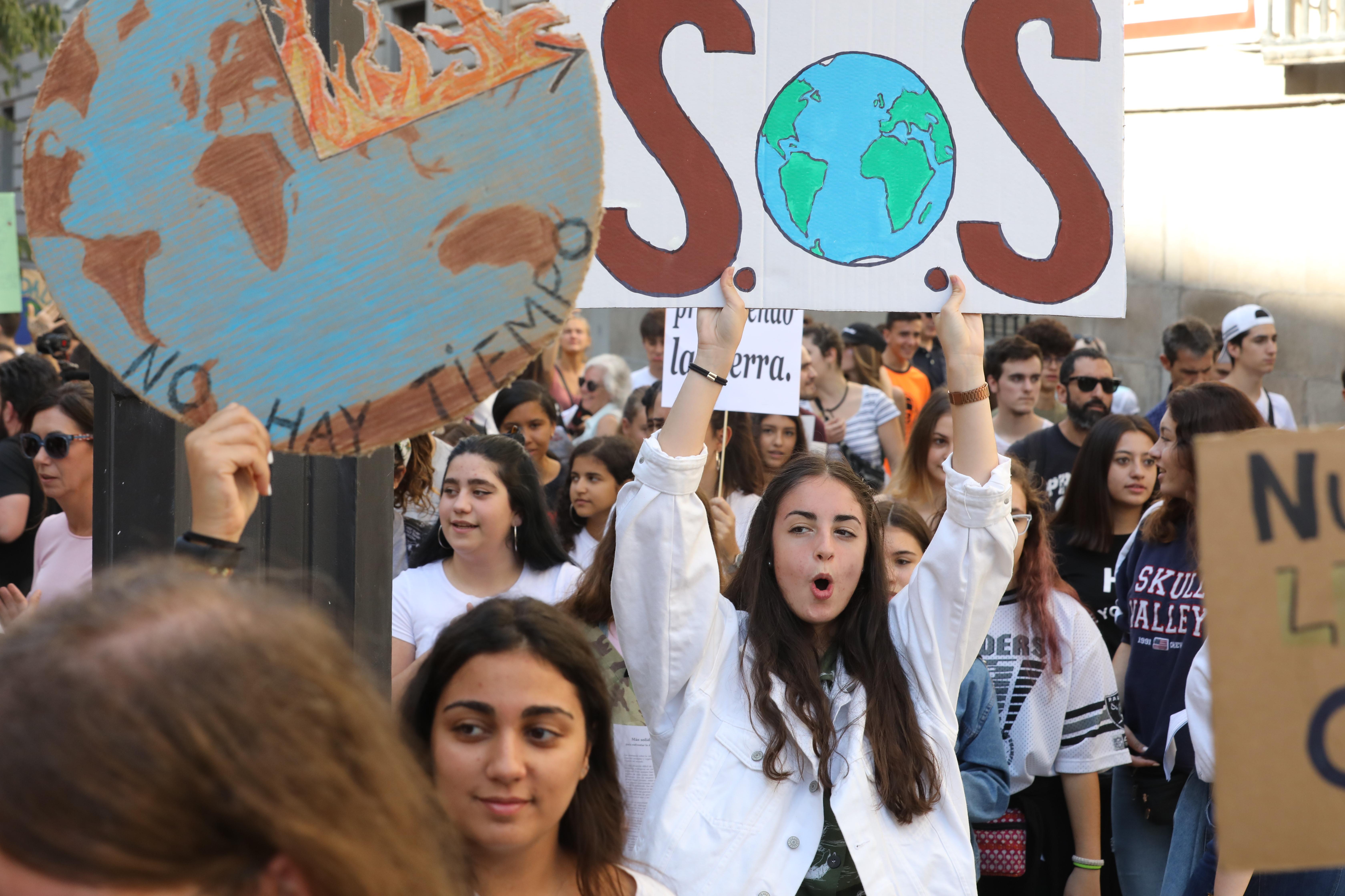 Una chica sujeta un cartel en el que se lee ` SOS´ durante la manifestación del Sindicato de Estudiantes por la Huelga Mundial por el Clima en la Puerta del Sol en Madrid a 27 de septiembre de 