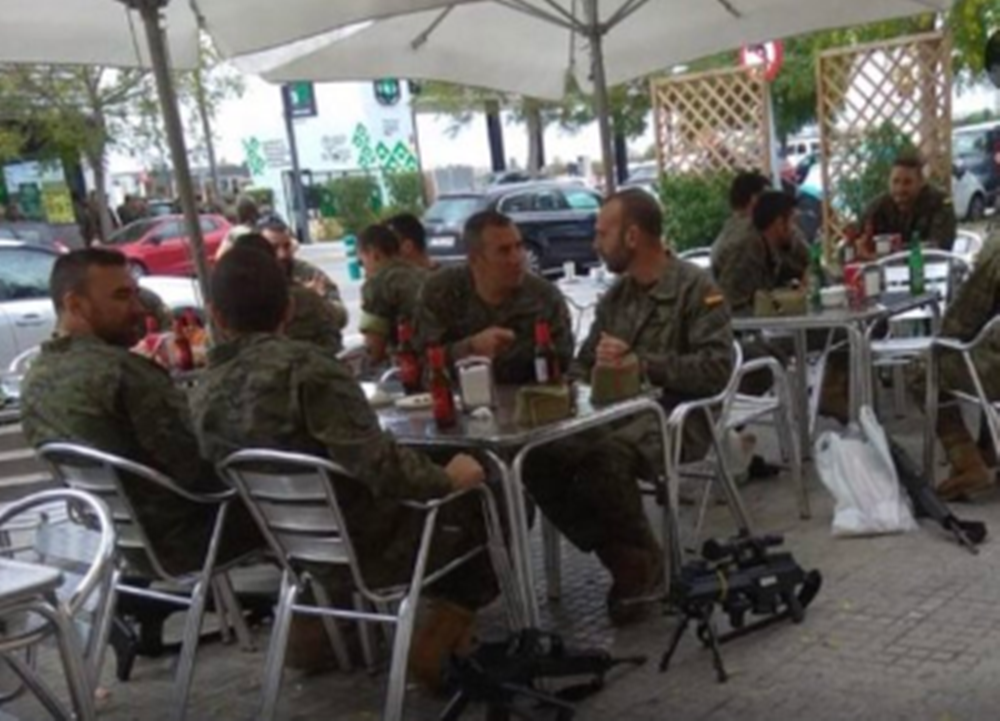 Imagen de los legionarios bebiendo cervezas con las armas en los pies.