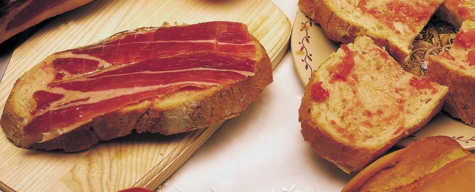 Pan tumaca, que no es otra cosa que pan con aceite, jamón y una pizca de sal. Es típico de Cataluña, donde también se le llama “pa amb tomàquet”. Foto: Web Turismo