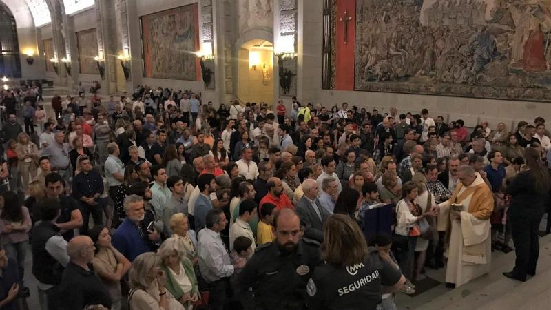 Un cura reparte la hostia consagrada a los rezagados en la misa por Franco en el Valle de los Caídos. Irene Garrido