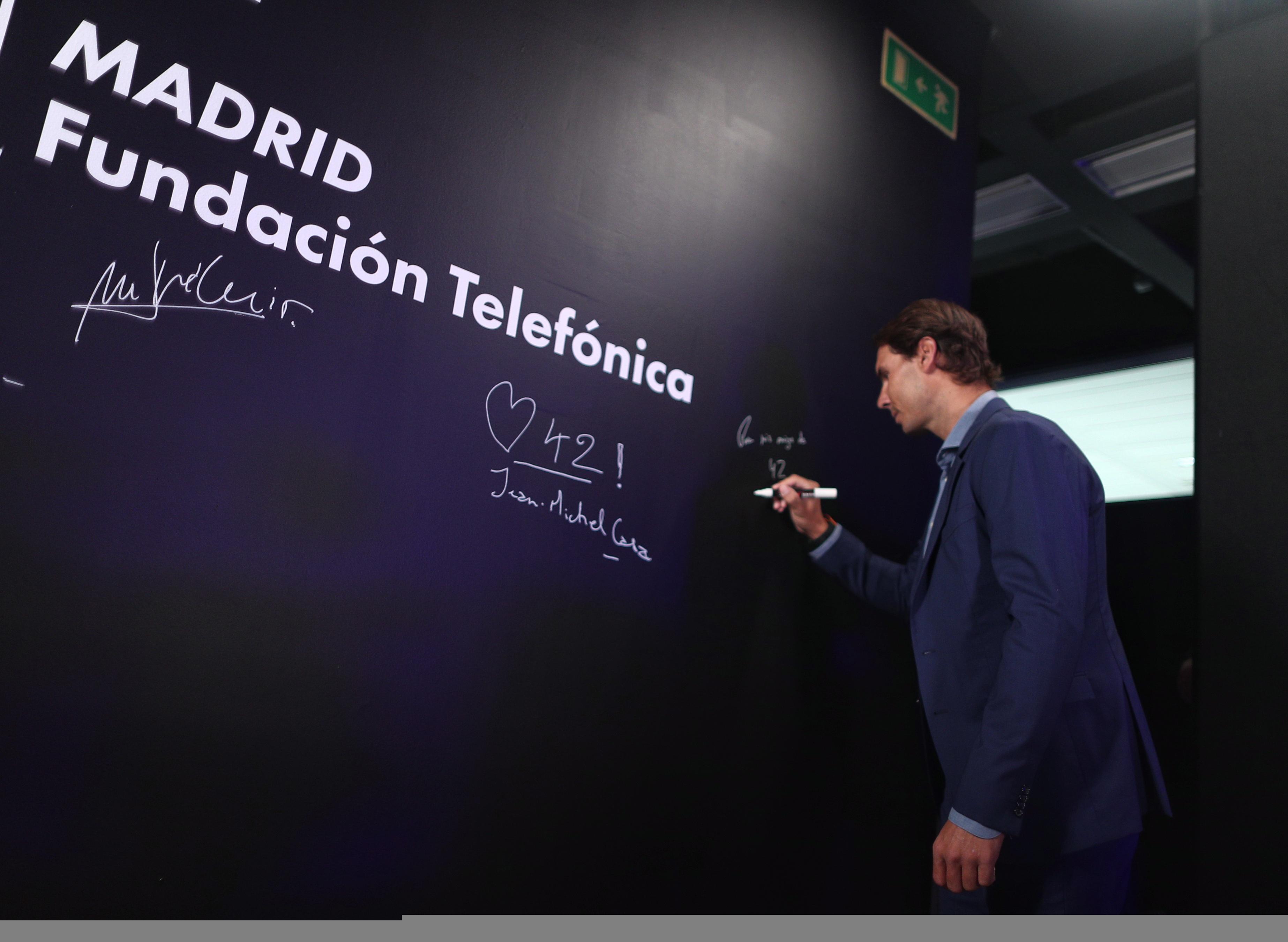 El embajador de Teléfonica y jugador de Tenis Rafa Nadal firma en la pizarra en su visita a 42 Madrid. Europa Press.