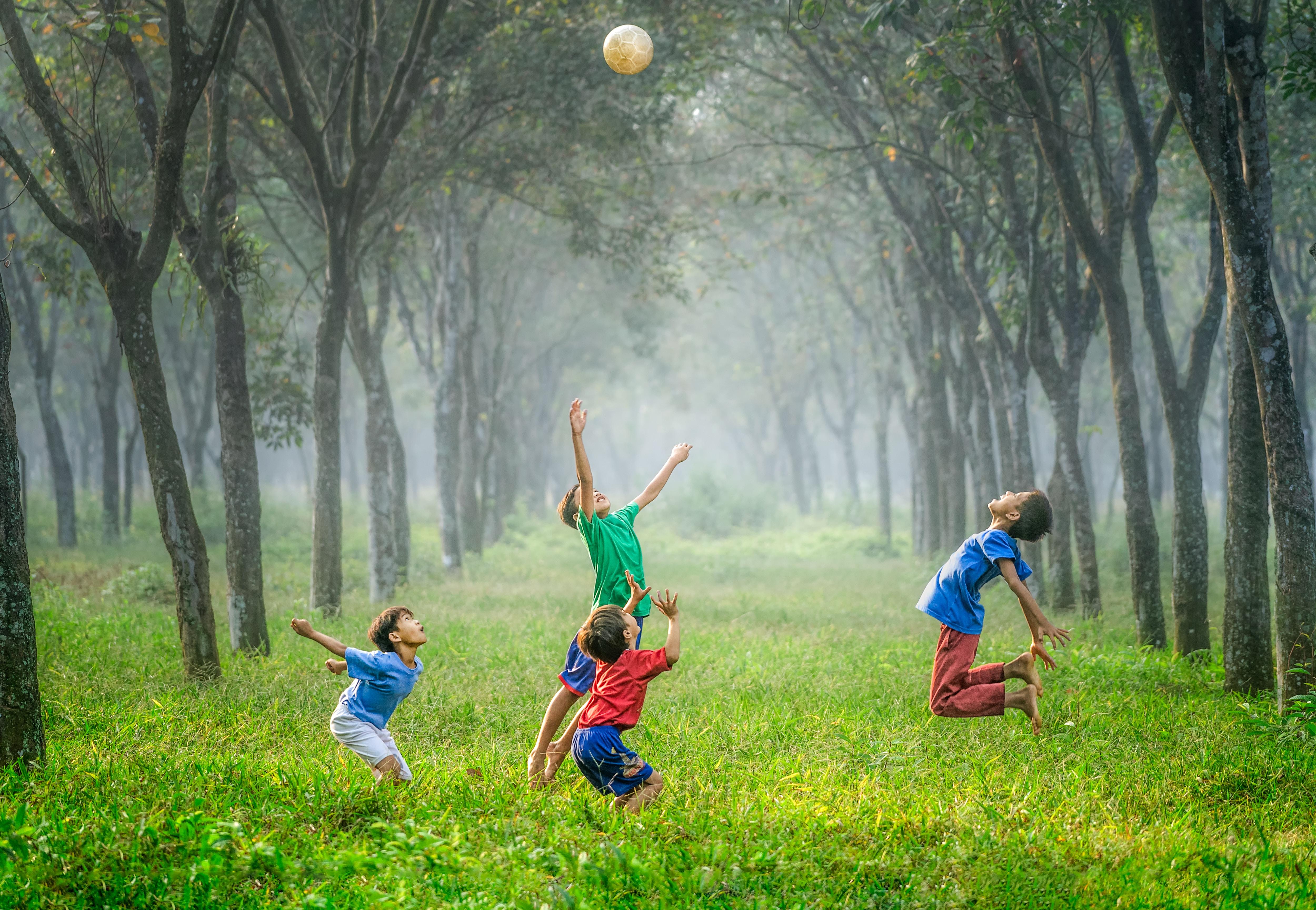 Cuatro niños juegan con una pelota. Foto: Robert Collins