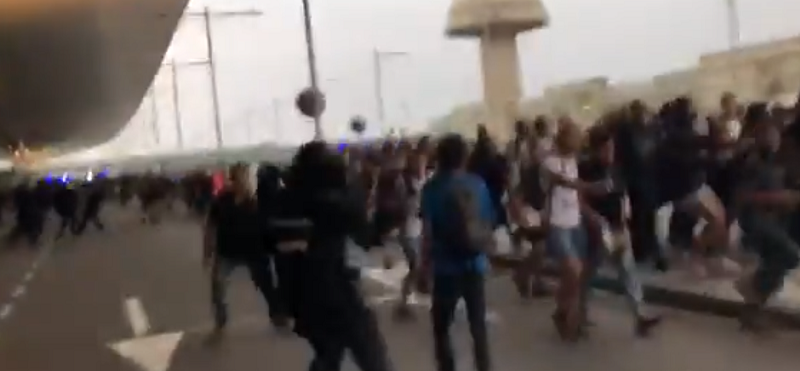 Captura de pantalla del momento en el que un mosso agrede por la espalda y en la cabeza a un manifestante. Fuente: Twitter.