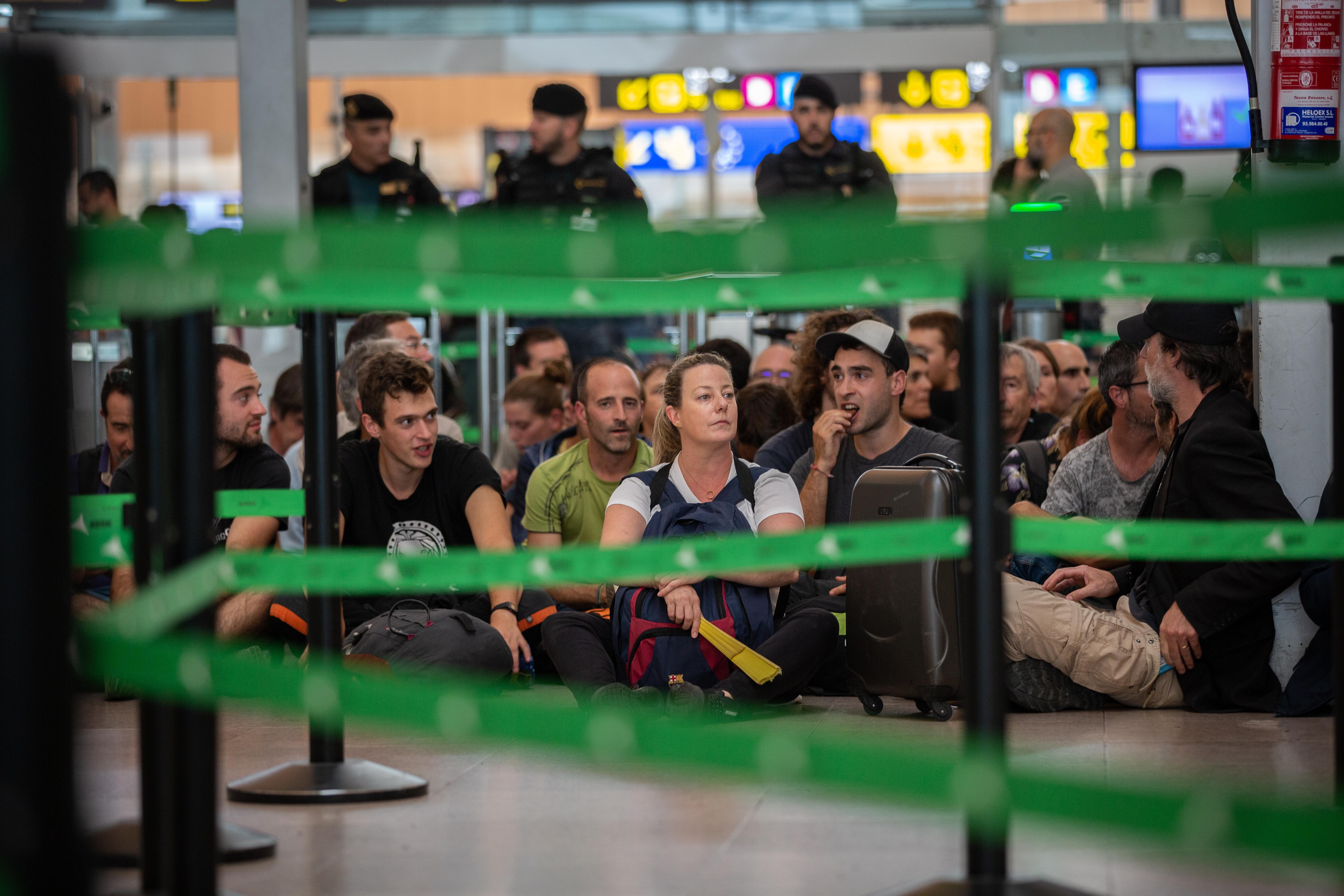 Un grupo de personas permanece sentado en el Aeropuerto de Barcelona El Prat en protesta por la sentencia del Tribunal Supremo