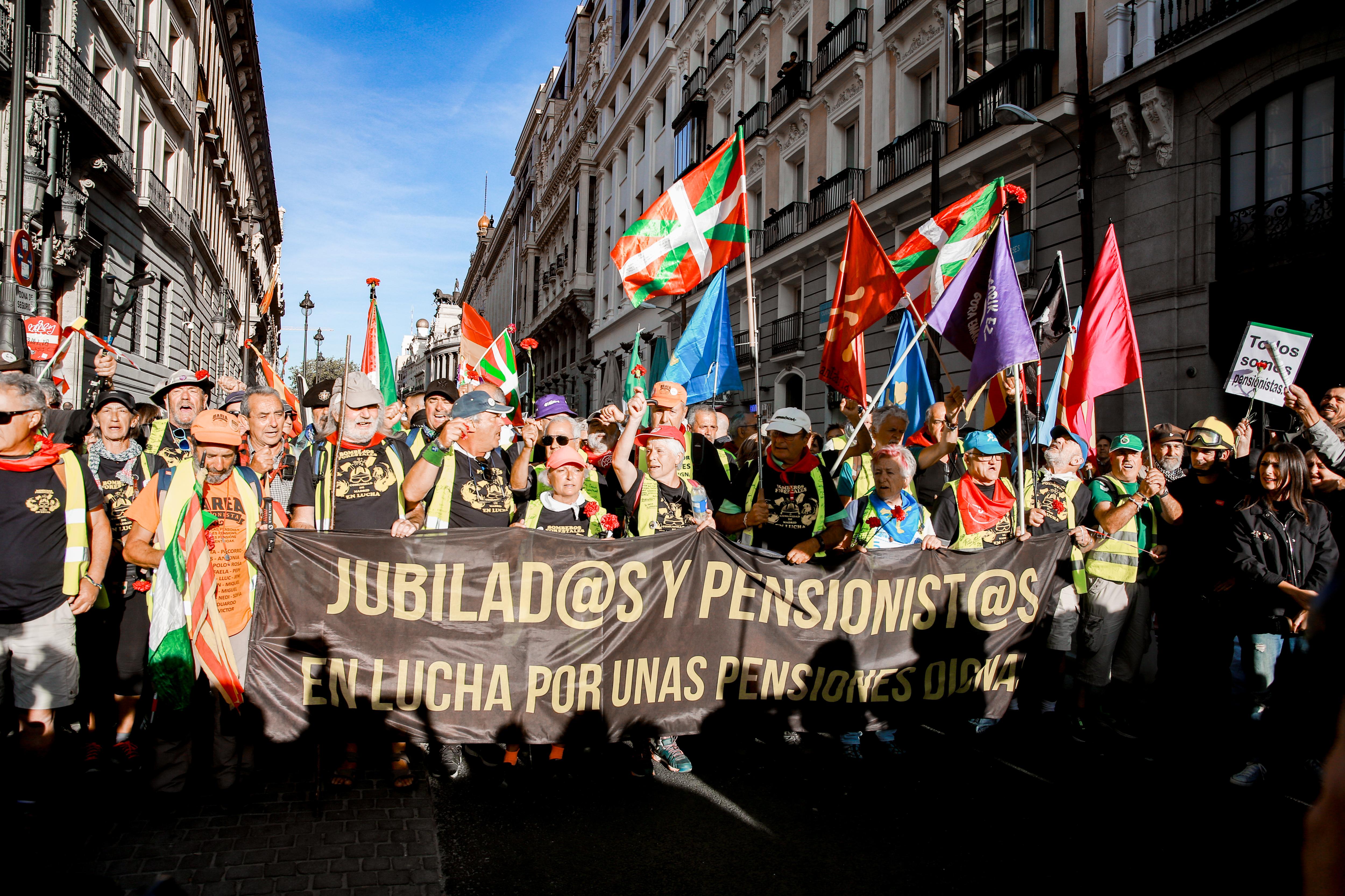 Participantes en la marcha de pensionistas con un cartel que dice 'Jubilad@s y pensionist@s En lucha por unas pensiones dignas' 