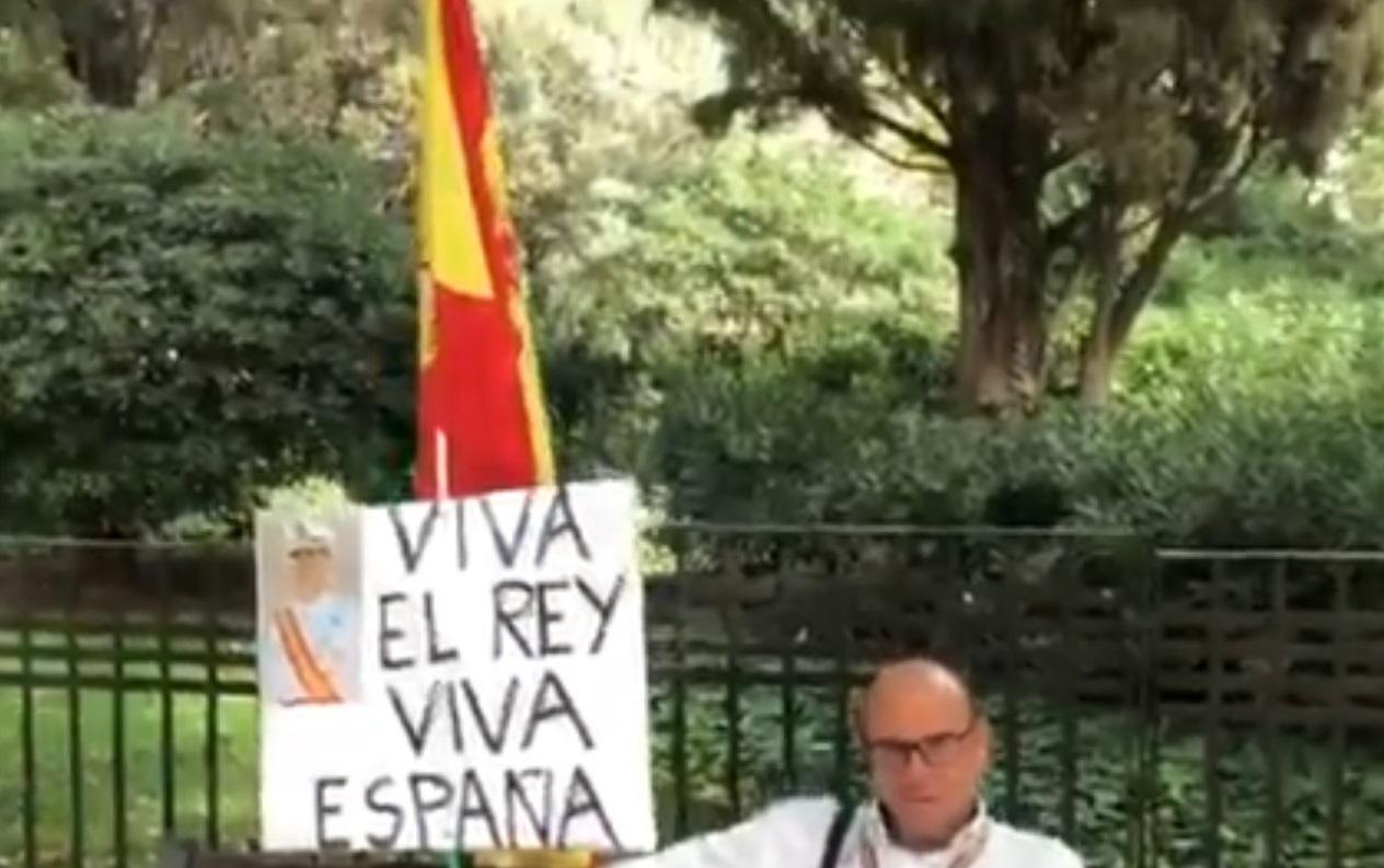 Un hombre reivindica pacificamente la unidad de España a unos metros de la manifestación. Twitter