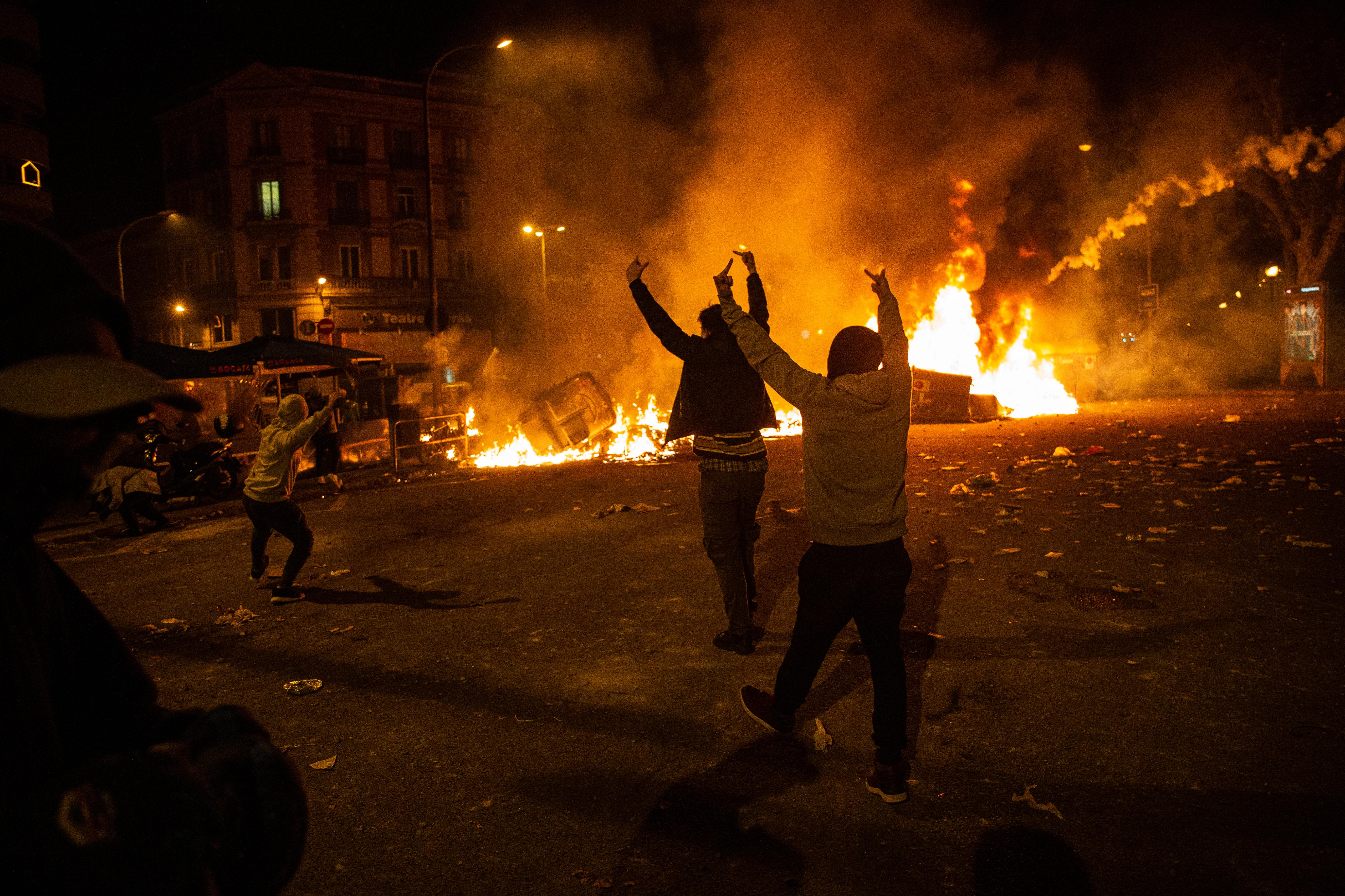 Varios manifestantes frente al fuego durante los disturbios en Barcelona (España) a 18 de octubre de 2019 