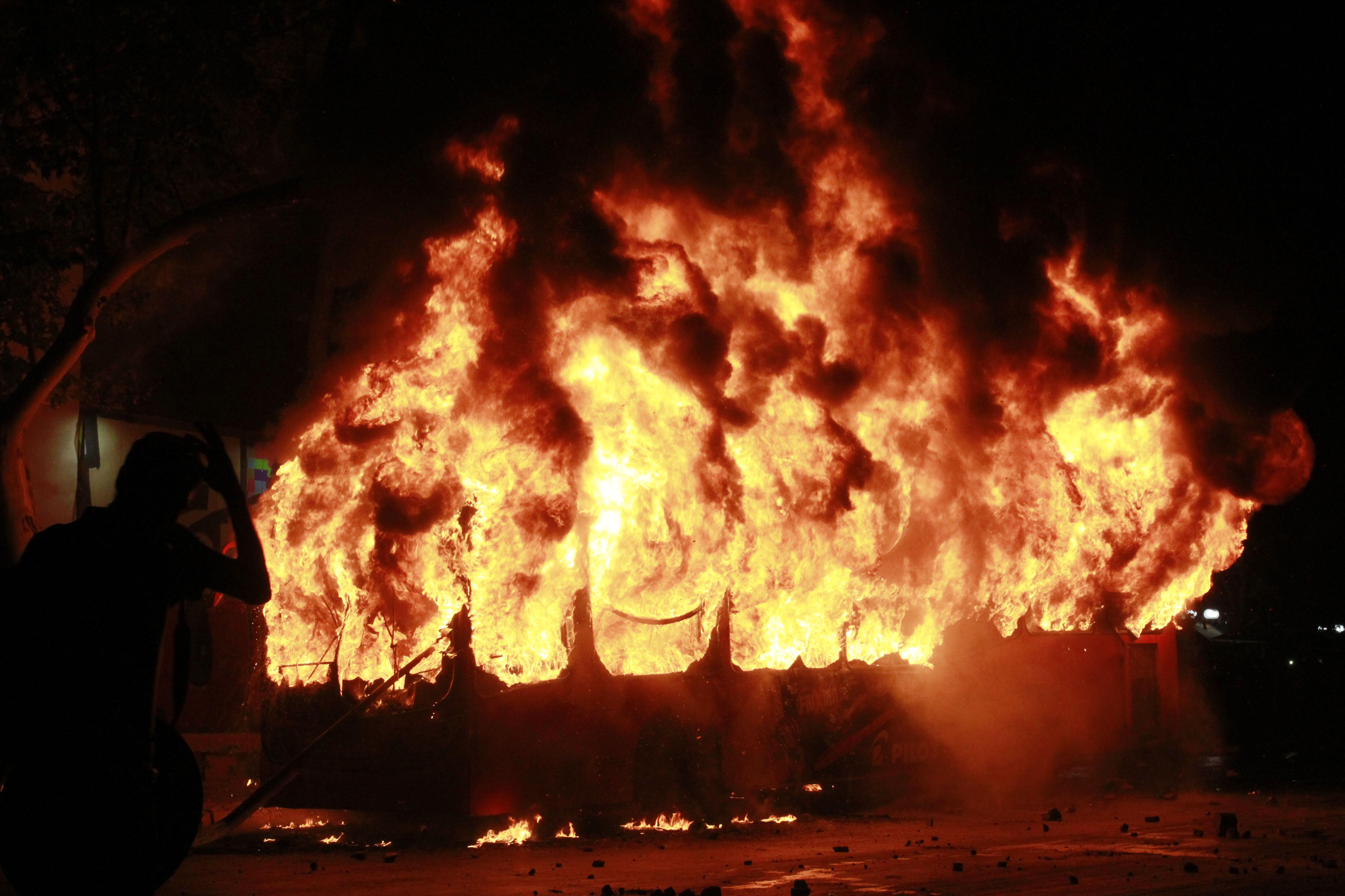 Un autobús ardiendo durante las protestas. Fuente: Europa Press.