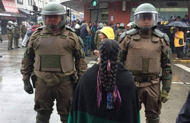 Una mujer enfrente de dos militares. Fuente: Redes sociales.