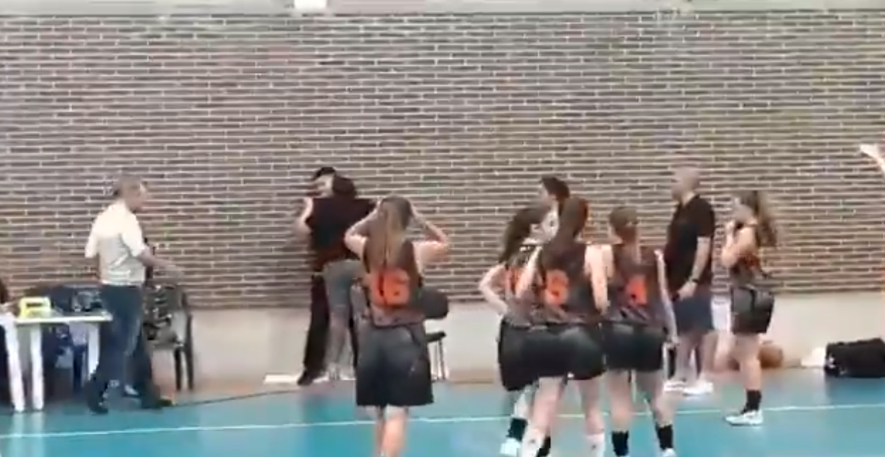 Una mujer agarra del cuello a un árbitro durante un partido de baloncesto