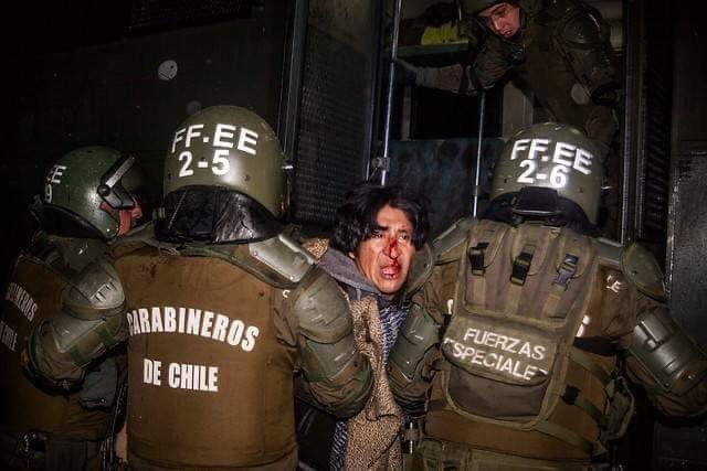 Dos militares se llevan detenido a un manifestante ensangrentado. Fuente: Redes sociales.