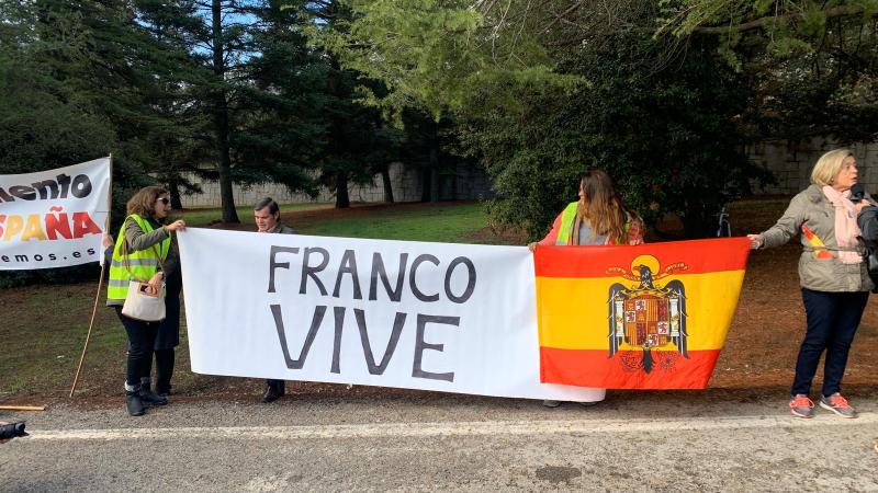 "Franco Vive" junto a una bandera preconstitucional en la puerta del Valle de los Caídos