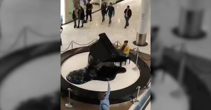 Fotograma del vídeo en el que la mujer toca el 'Cara al sol' en un centro comercial de Valladolid. Fuente: Twitter.