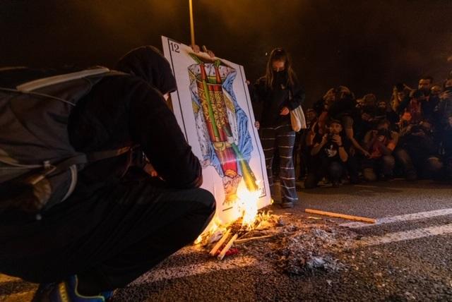 Manifestantes queman fotos del Rey y banderas españolas en la Diagonal en la protesta por el acto de la FPdGi en el Palau de Congressos de Catalunya con la Familia Real
