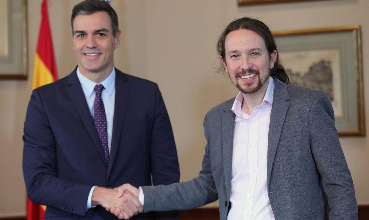 Pedro Sánchez y Pablo Iglesias se estrechan la mano tras firmar el acuerdo. JESÚS HELLÍN/EP