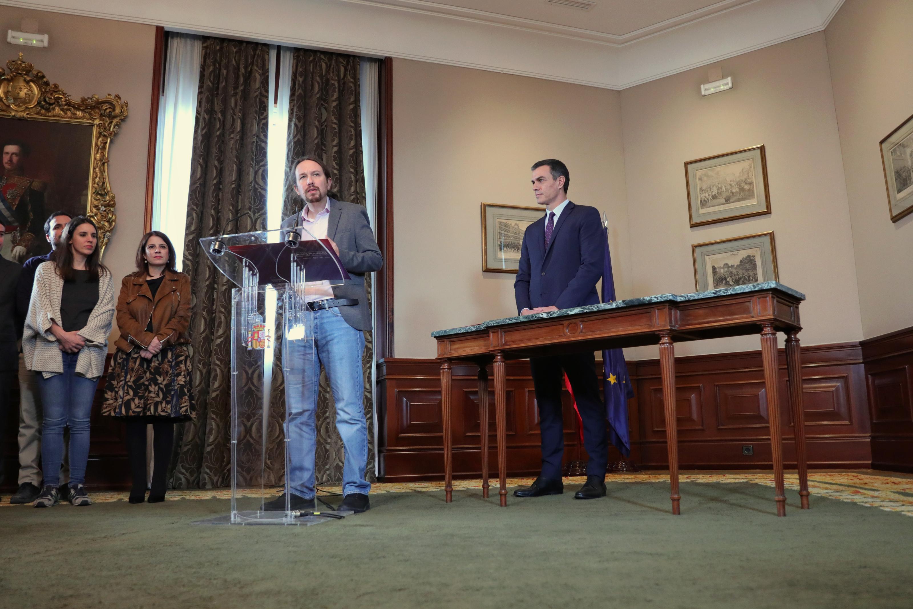 El presidente del Gobierno en funciones Pedro Sánchez y el líder de Podemos Pablo Iglesias se abrazan en el Congreso de los Diputados después de firmar el acuerdo de coalición.