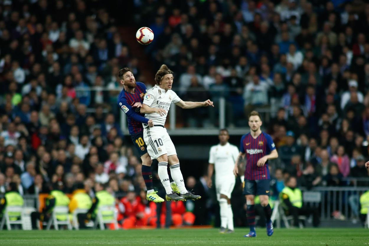 Leo Messi saltando junto a Luka Modric
