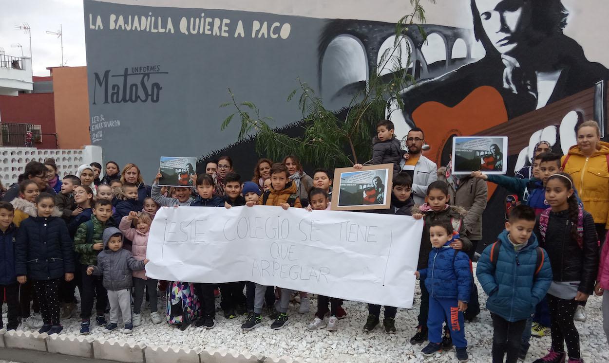 Alumnos y padres del colegio algecireño Campo de Gibraltar, en el barrio de La Bajadilla, bajo el mural de Paco de Lucía.