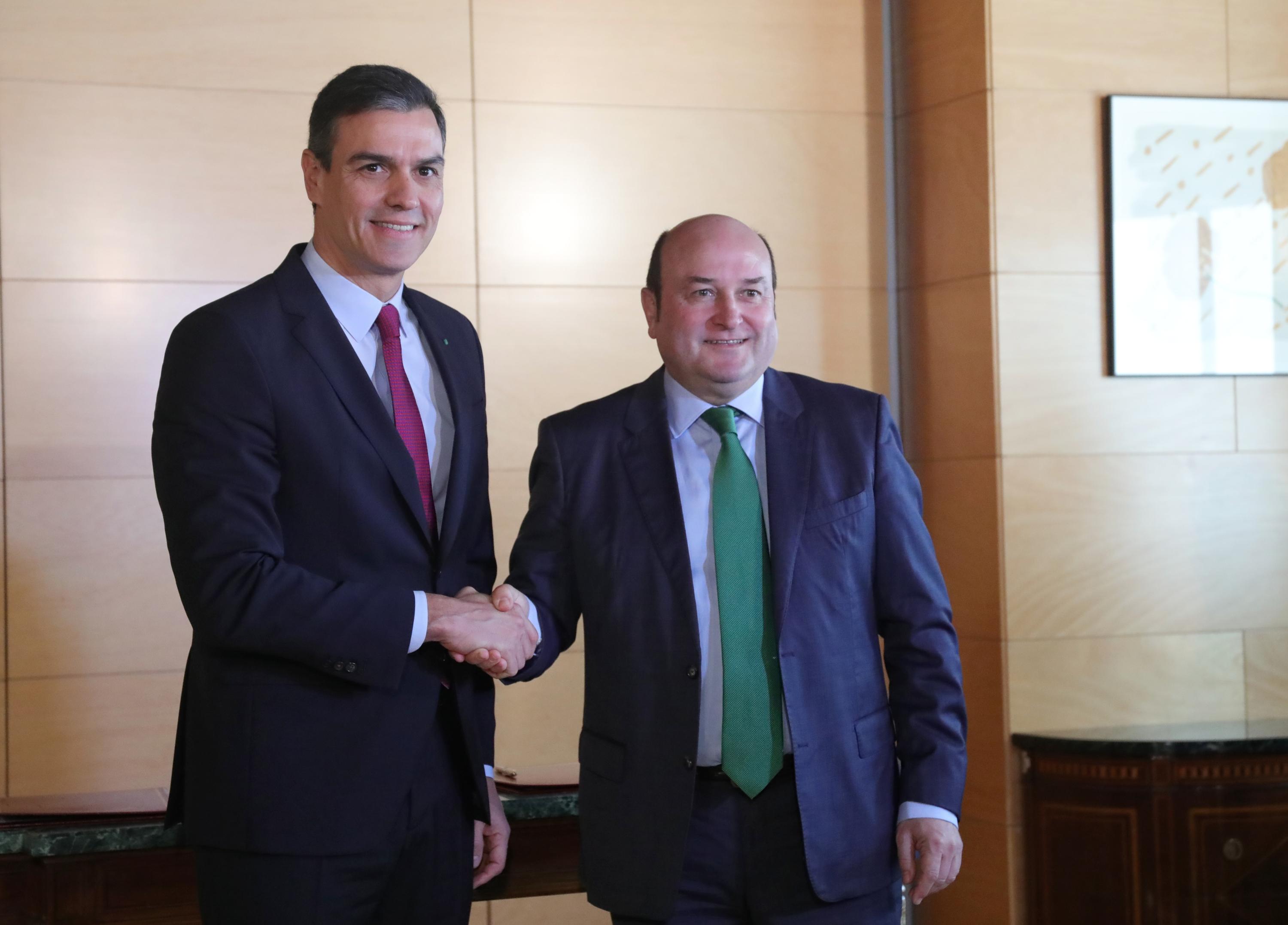 El presidente del Gobierno, Pedro Sánchez, y el presidente del PNV Andoni Ortuzar se dan la mano tras firmar el acuerdo entre el PSOE y el PNV para la investidura. Europa Press.