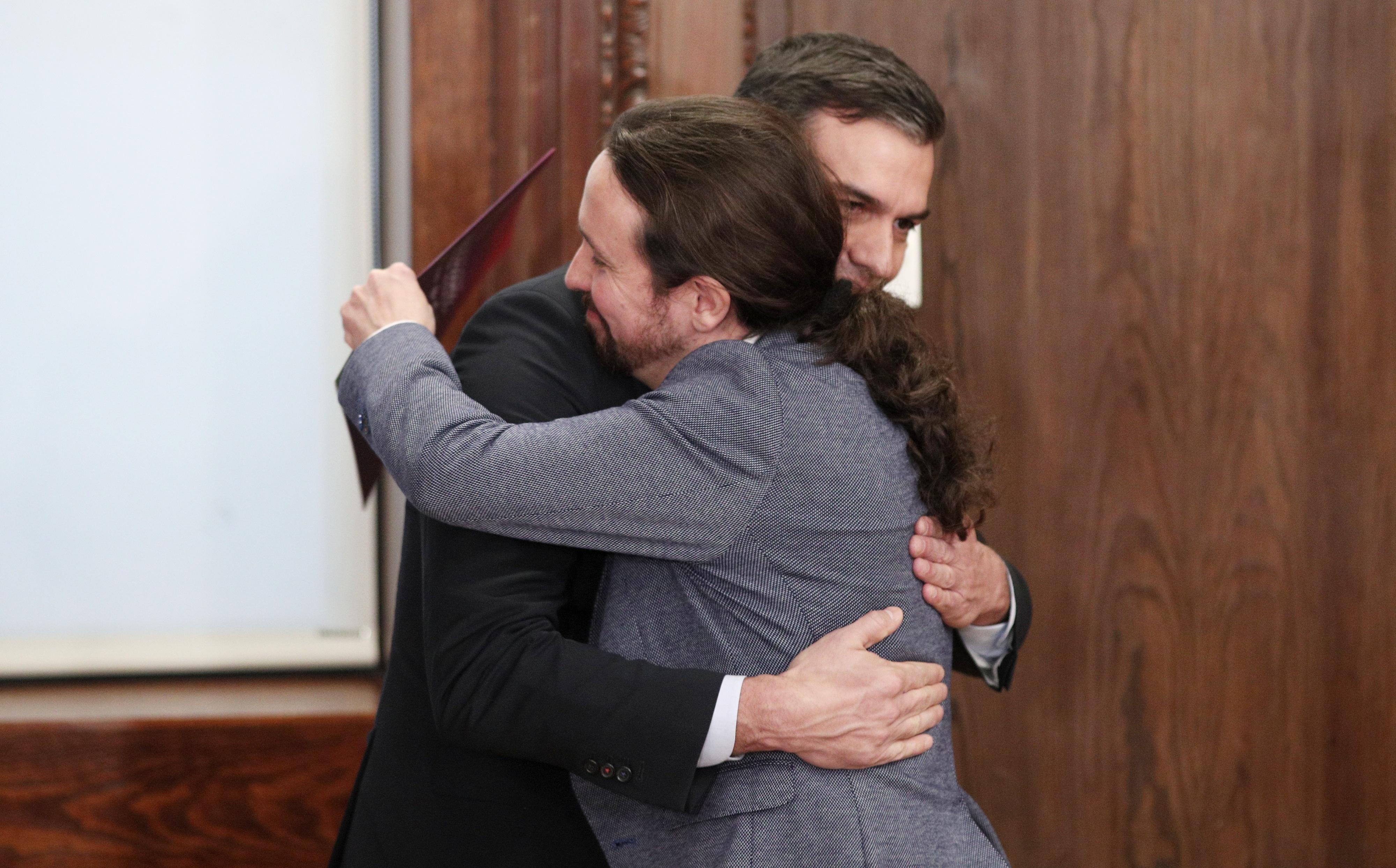 Pedro Sánchez y Pablo Iglesias se dan un abrazo durante el acto de presentación del programa de Gobierno de coalición. Europa Press.