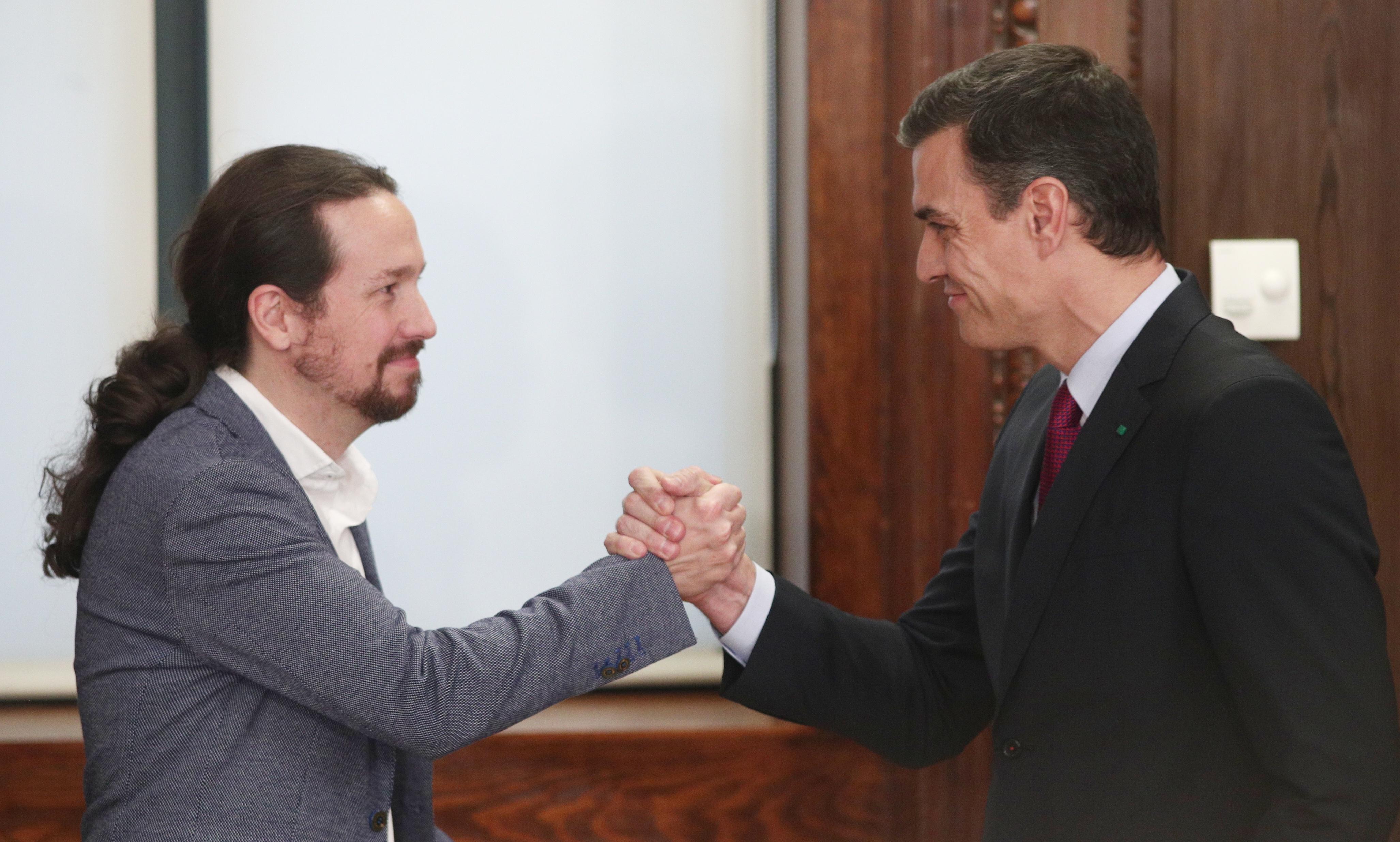 Pedro Sánchez y Pablo Iglesias se dan la mano durante el acto de presentación del programa de Gobierno. Europa Press.