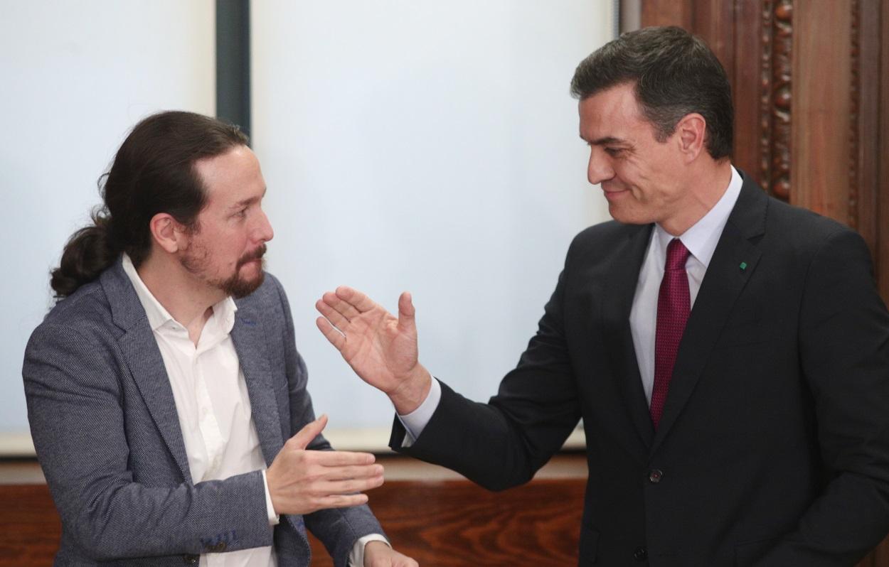 El presidente del Gobierno en funciones, Pedro Sánchez (dech.) y el secretario general de Podemos, Pablo Iglesias (izq), se dan la mano durante el acto de presentación del programa de Gobierno del PSOE y Unidas Podemos