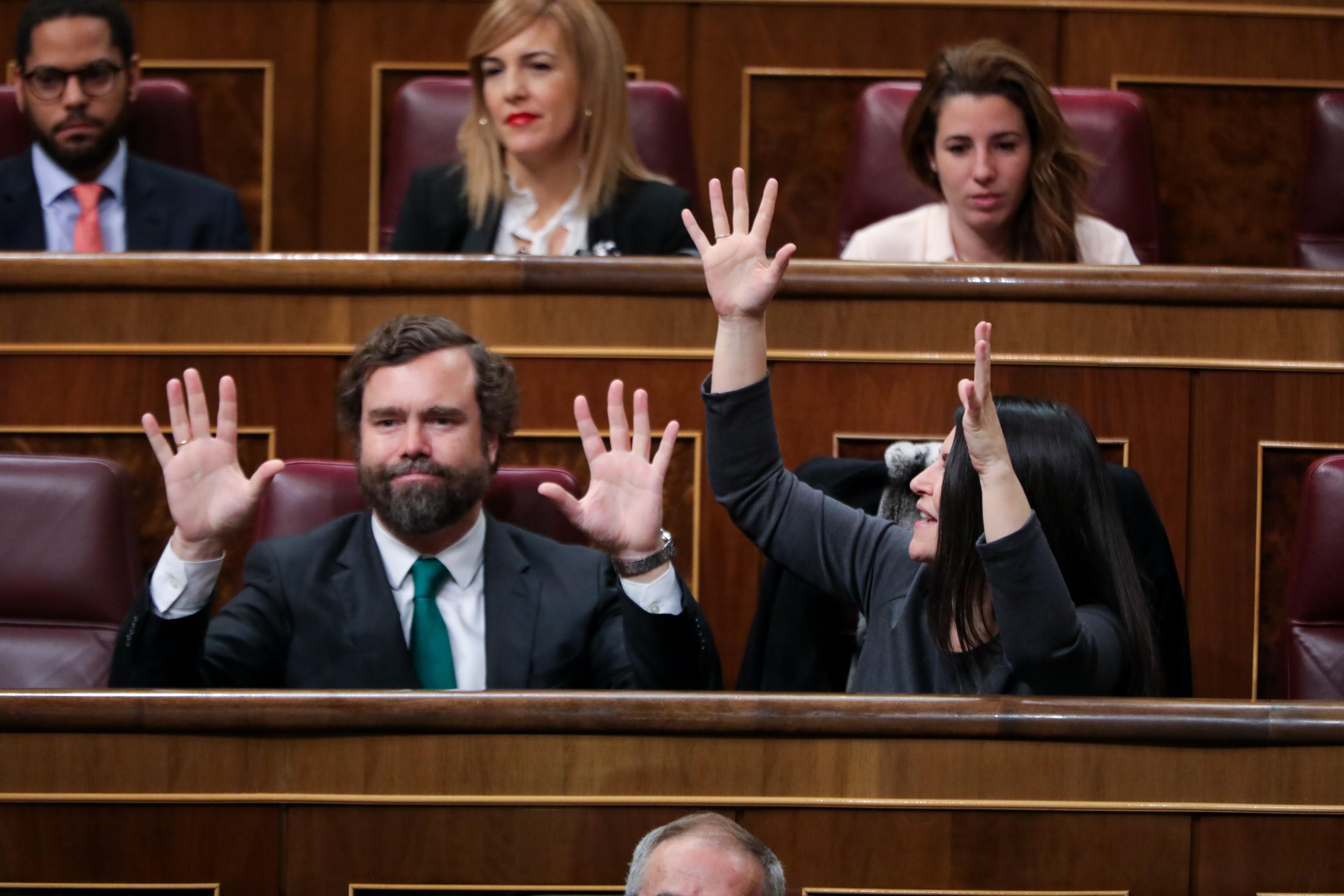 El portavoz VOX en el Congreso de los Diputados Iván Espinosa de los Monteros y la secretaria general del Grupo Parlamentario de VOX Macarena Olona levatan las manos durante la intervención 