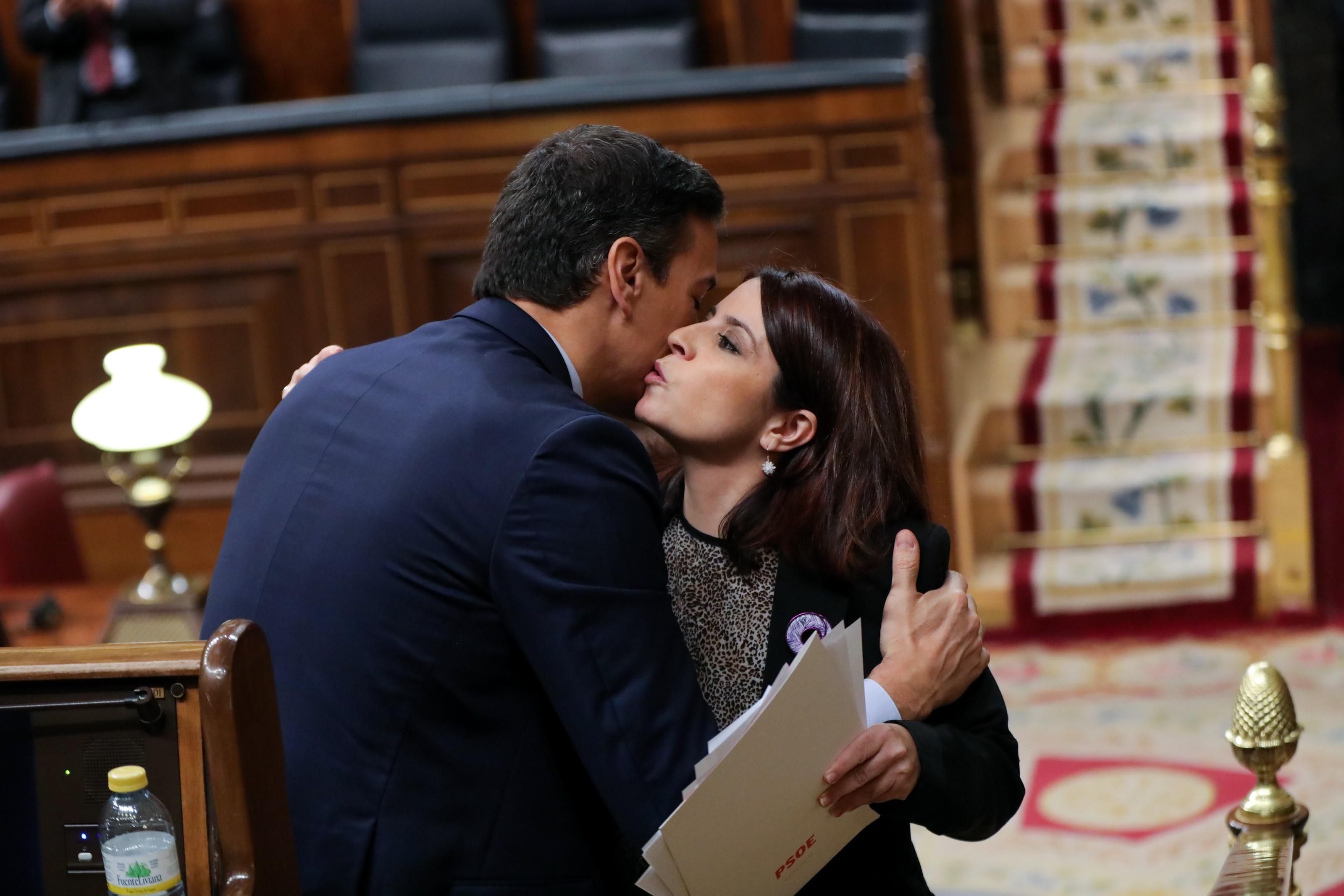 El presidente del Gobierno en funciones Pedro Sánchez y la portavoz del PSOE en el Congreso Adriana Lastra se dan un beso tras la intervención de Lastra 