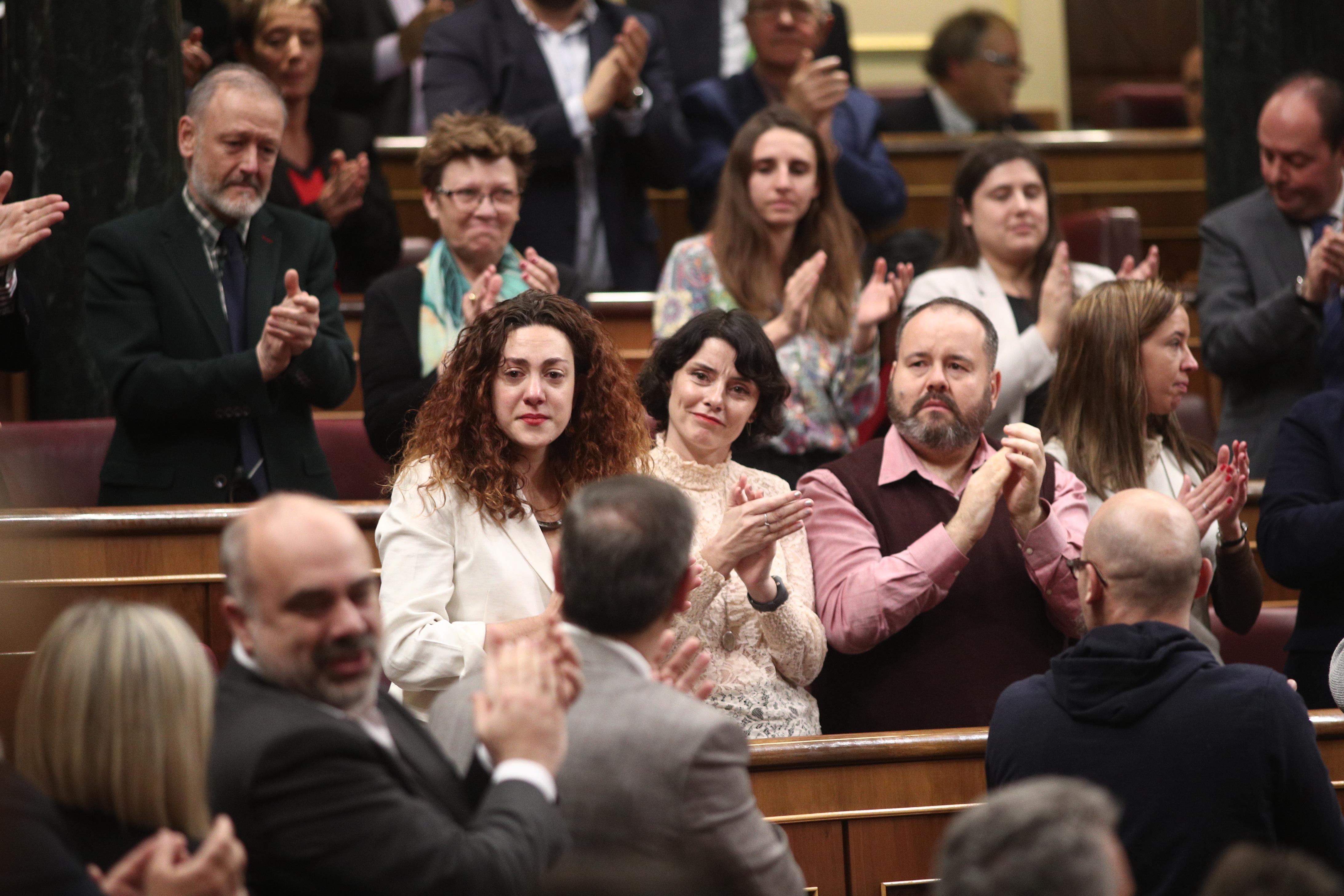 La diputada de Unidas Podemos Aina Vidal (con chaqueta blanca) se emociona al recibir el aplauso de su bancada junto la socialista tras el agradecimiento que le ha expresado Pablo Iglesias