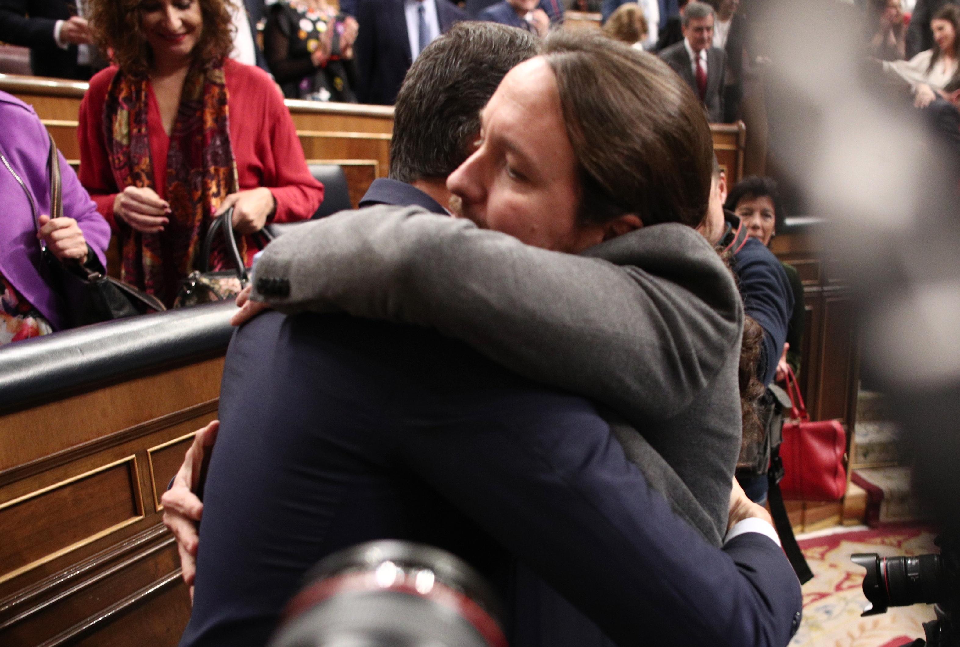 El secretario general de Podemos Pablo Iglesias abraza al presidente del Gobierno Pedro Sánchez tras ser elegido al finalizar la segunda sesión de votación para la investidura del candidato soci