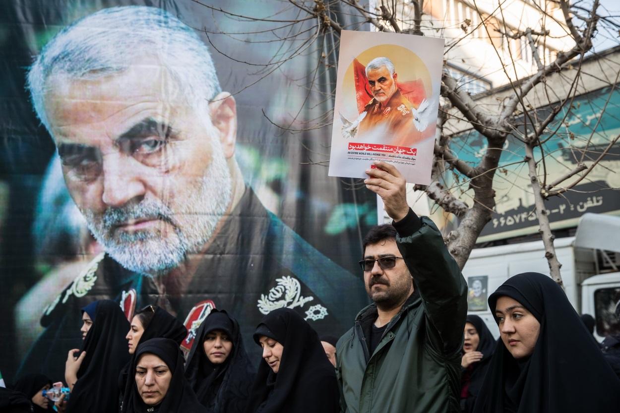 Asistentes al funeral de Qasem Soleimani sostienen imágenes suyas