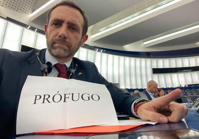 Bauzá enseña su cartel de 'prófugo' mientras habla Puigdemont en la Eurocámara