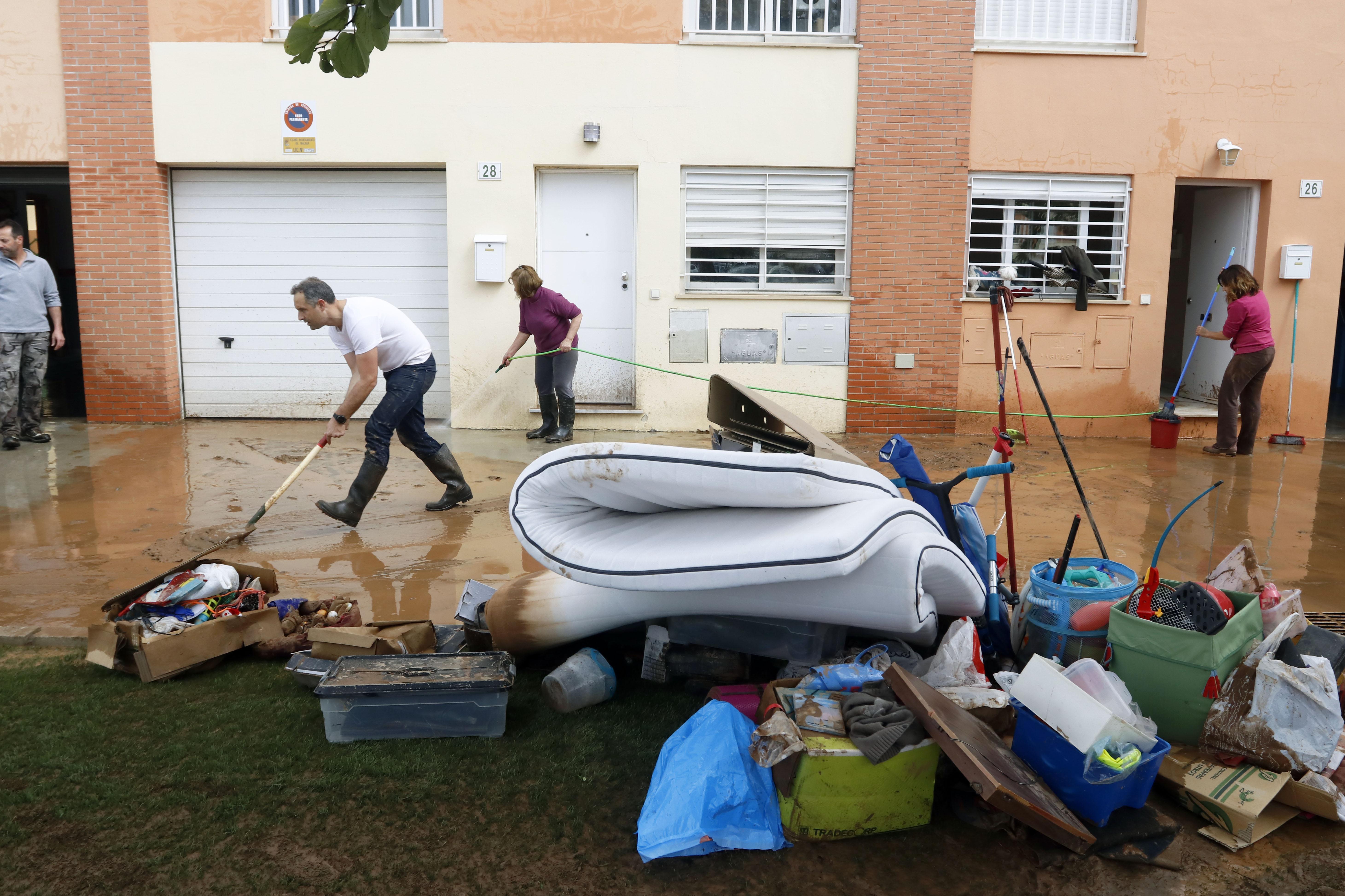 Vecinos de la barriada malagueña de Campanillas se afanan en las limpiezas de sus hogares y calles del barrio tras la tromba de aguda caída esta pasada madrugada a consecuencia de la Tormenta Gloria que azota al país