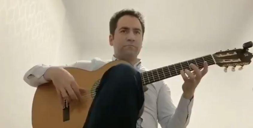 Teodoro García Egea, toca la guitarra en su habitación
