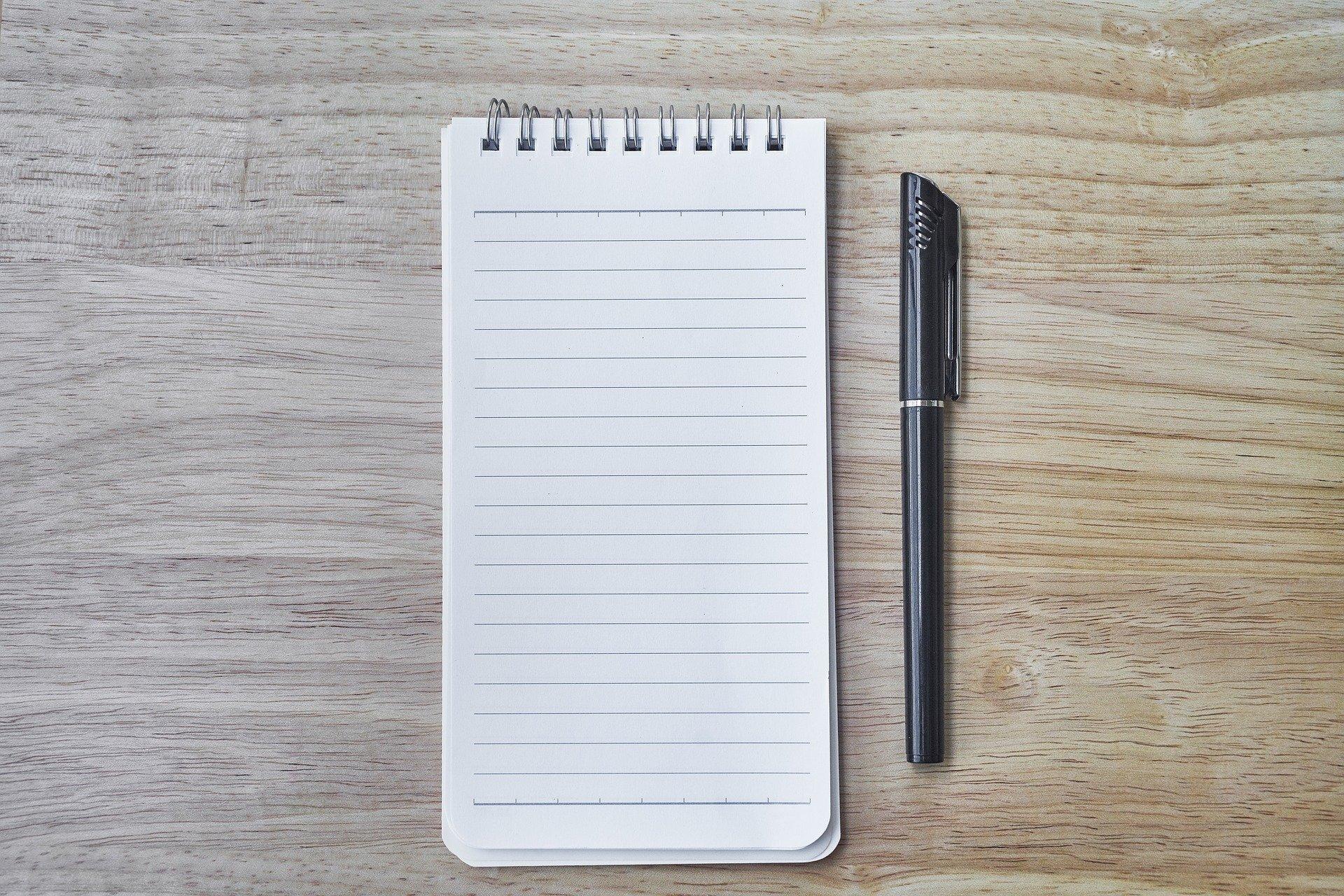 Un bolígrafo y un cuaderno de notas. Fuente: Pixabay.