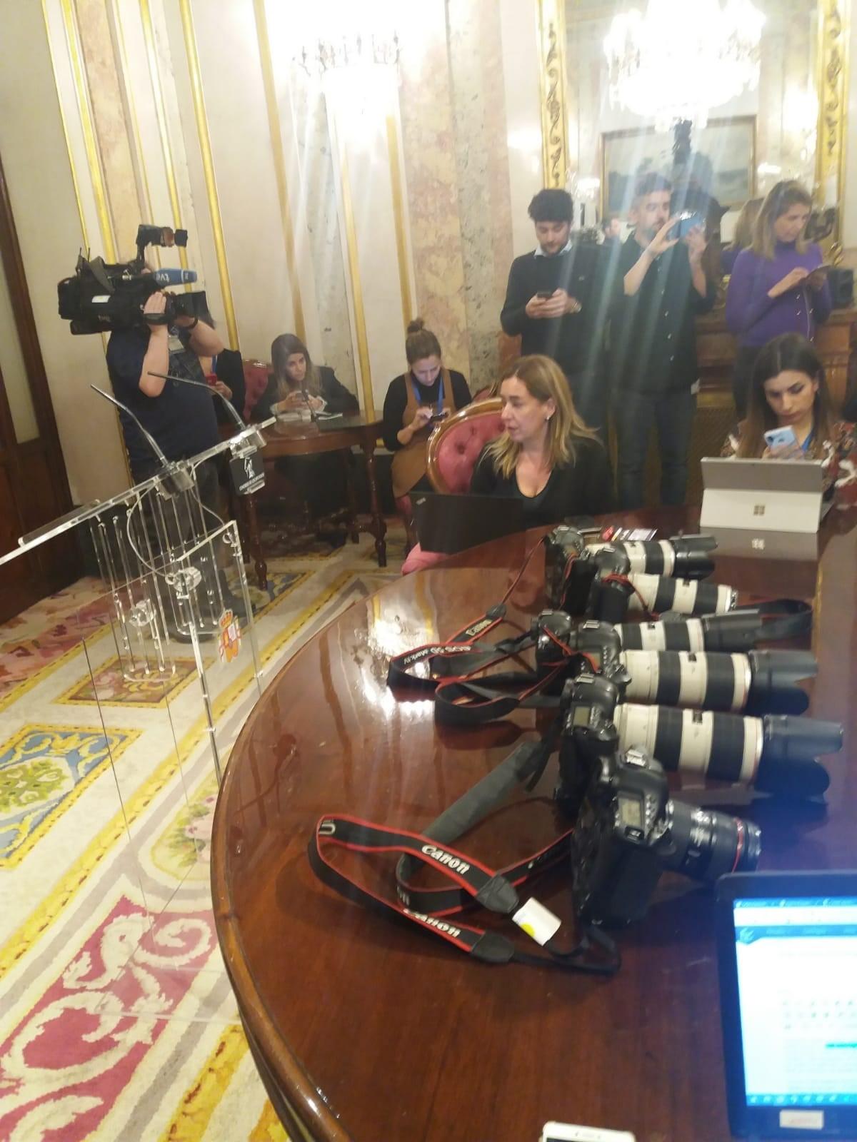 Reporteros gráficos protestan con sus cámaras sobre el escritorio después de que PP y Cs les impidieran cubrir una reunión en el Congreso