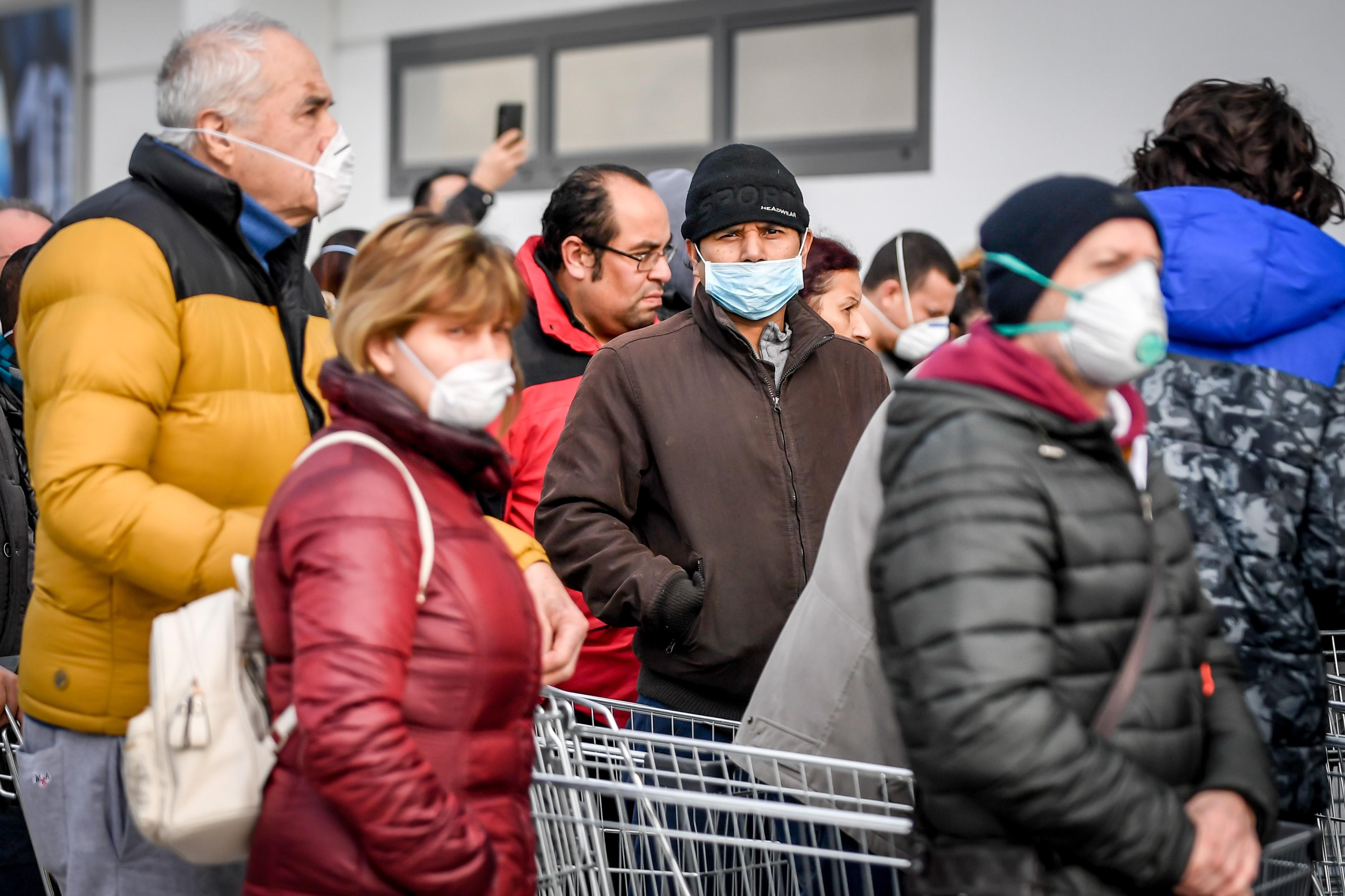 Personas con máscaras hacen cola frente a un supermercado en Casalpusterlengo, Italia, donde se ha detectado la propagación del coronavirus. EP