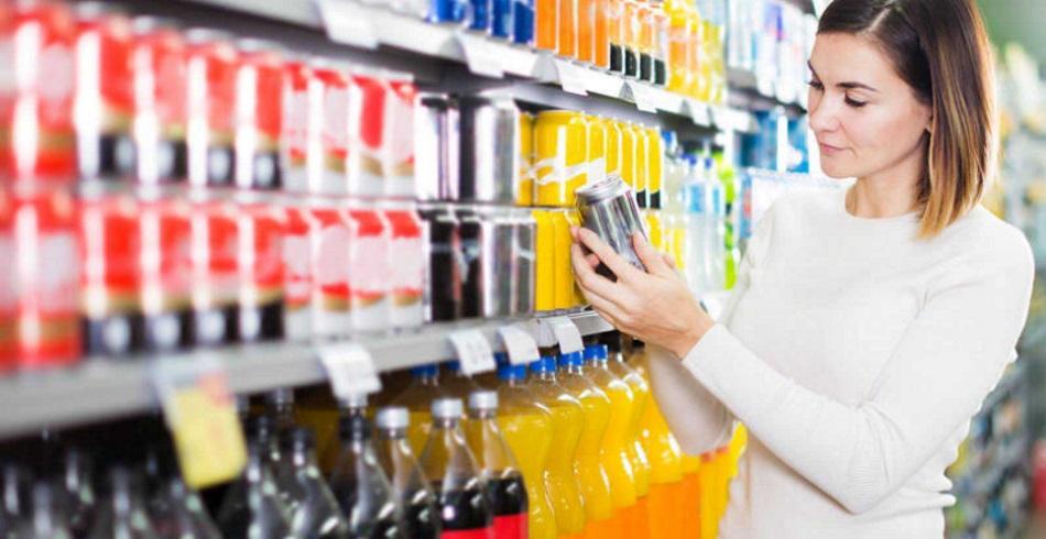 Una consumidora mira una bebida en un supermercado. Fuente: RTVE