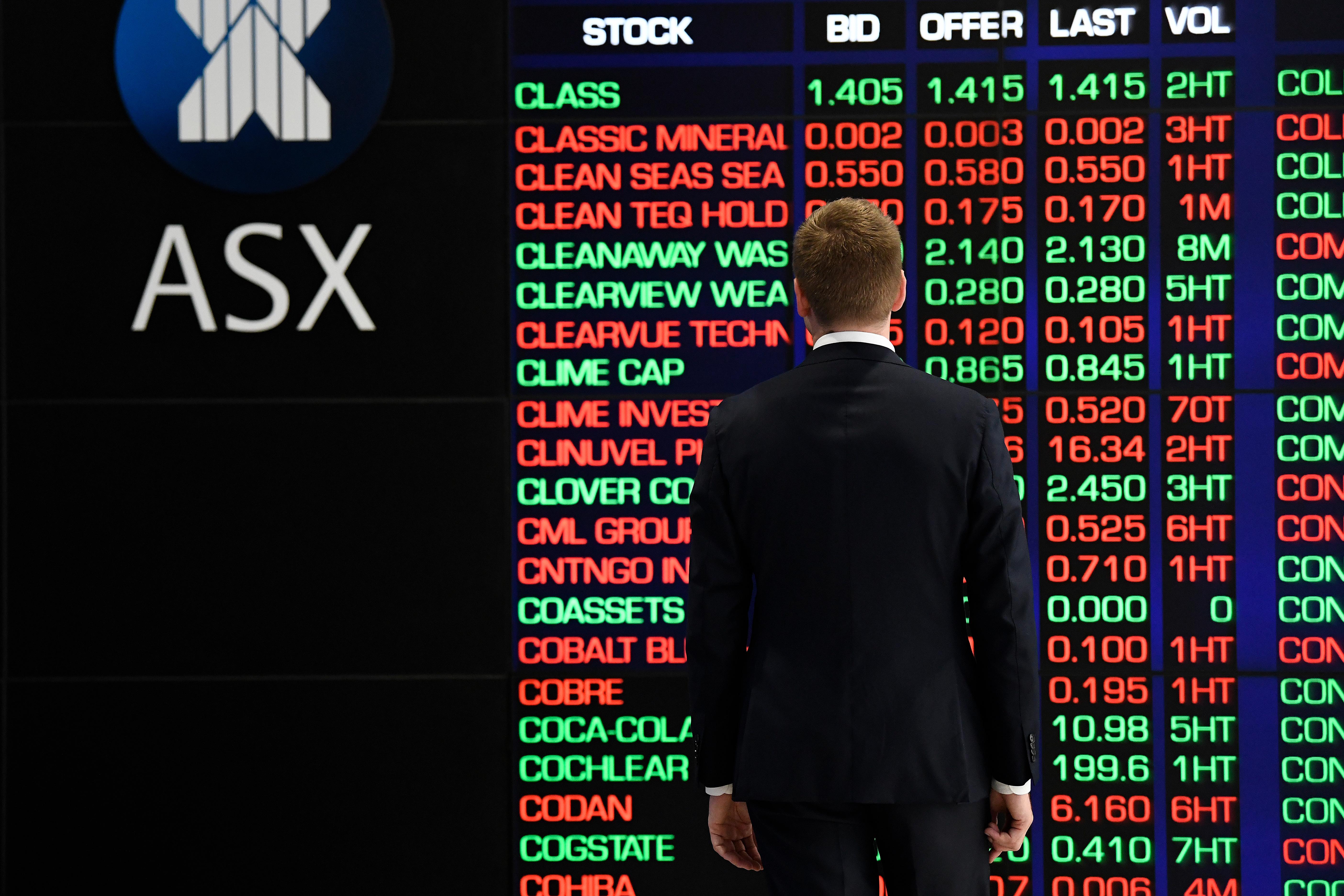 Un corredor de bolsa mira una pantalla con valores en la Bolsa de Australia