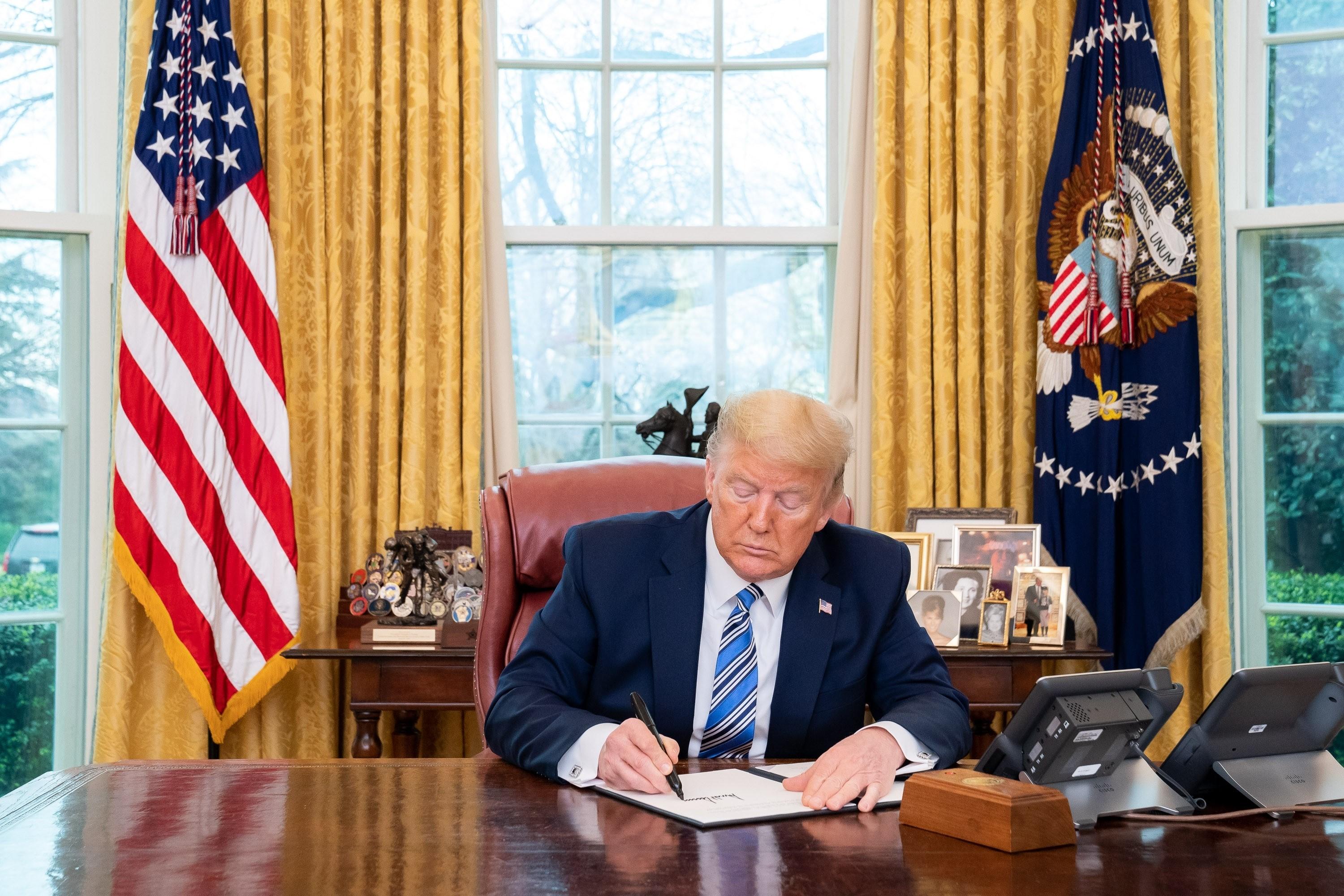 El presidente de Estados Unidos, Donald Trump, firma una ley en el Despacho Oval.